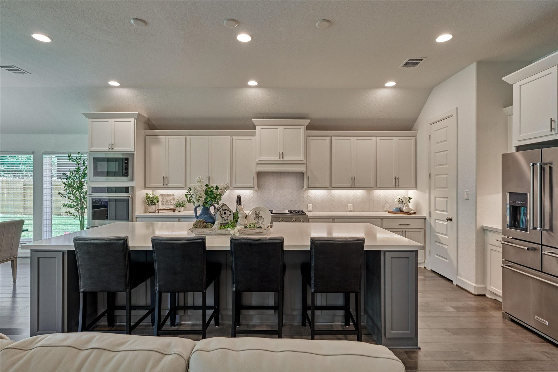 205 Patina Sorrel Drive, Montgomery, TX 77316 Stunning modern kitchen with an abundance of cabinetry, a spacious island with seating and more storage, and stainless-steel Monogram appliances. Bright and inviting.