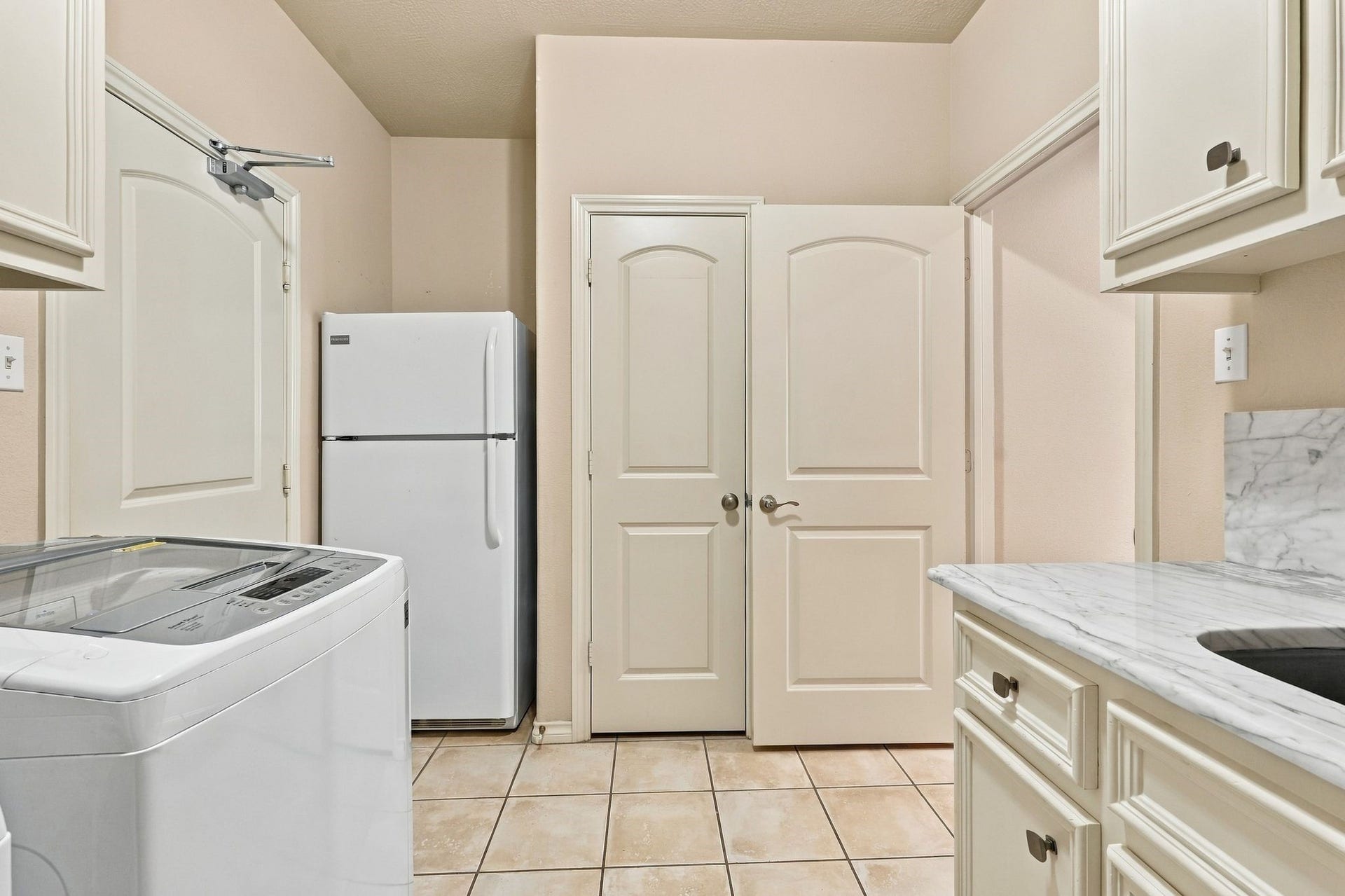 156 April Waters Drive W, Conroe, TX 77356 Utility room also has an extra refrigerator and large closet. Door to the left enters the attached garage. Garage has room for 2 vehicles, golf cart and plenty of room for work bench and storage.