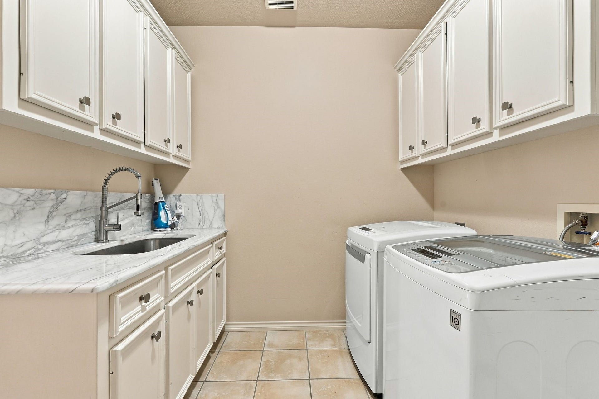 156 April Waters Drive W, Conroe, TX 77356 Utility room equipped with plenty of cupboards for storage, counter space for folding and a deep sink . Washer & dryer convey with home.
