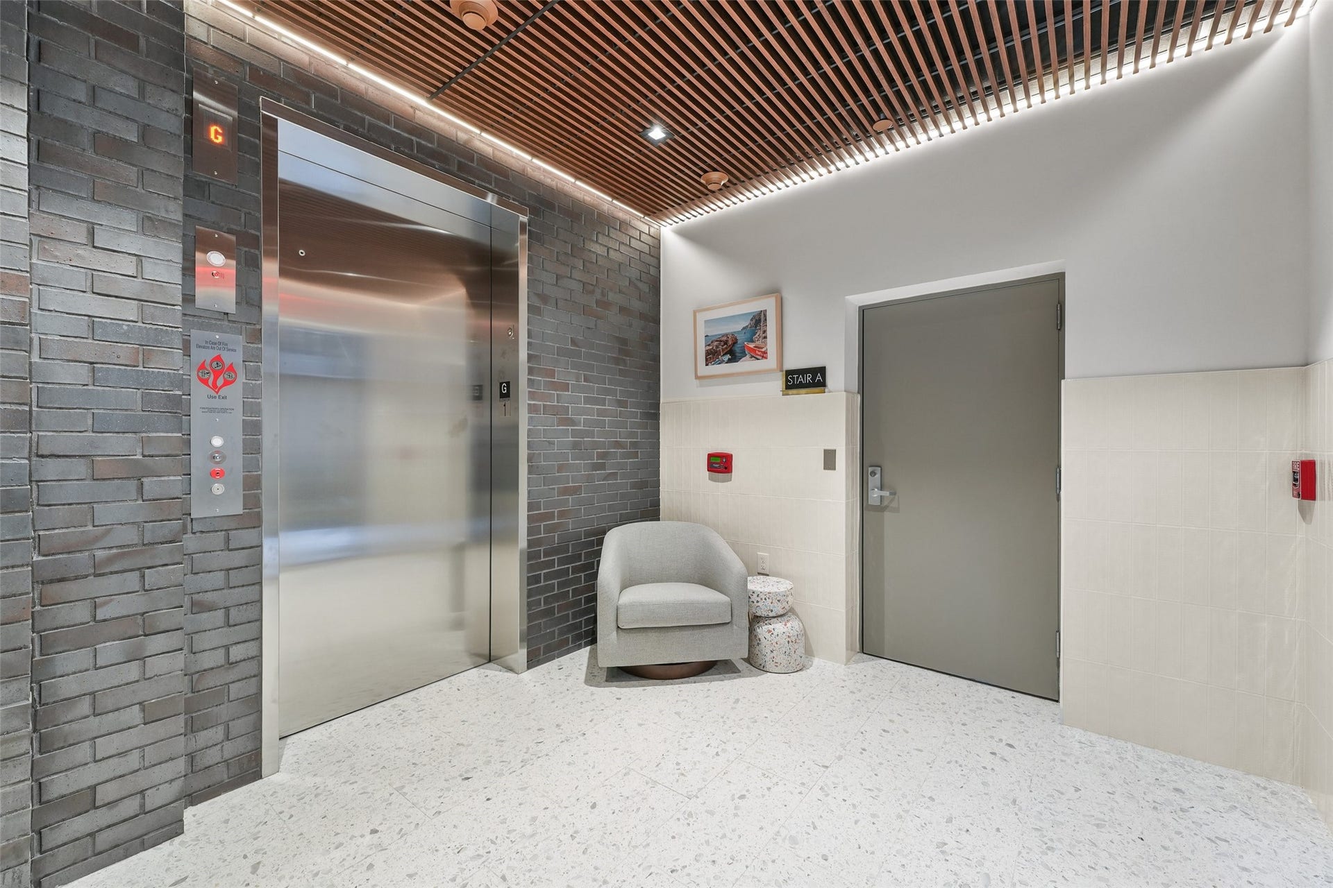 170 Malone Street, #3402, Houston, TX 77007 This modern lobby features a sleek elevator with a brick accent wall, a comfortable seating area, and stylish lighting. The space also includes a stairwell access door, providing convenience and a contemporary aesthetic.