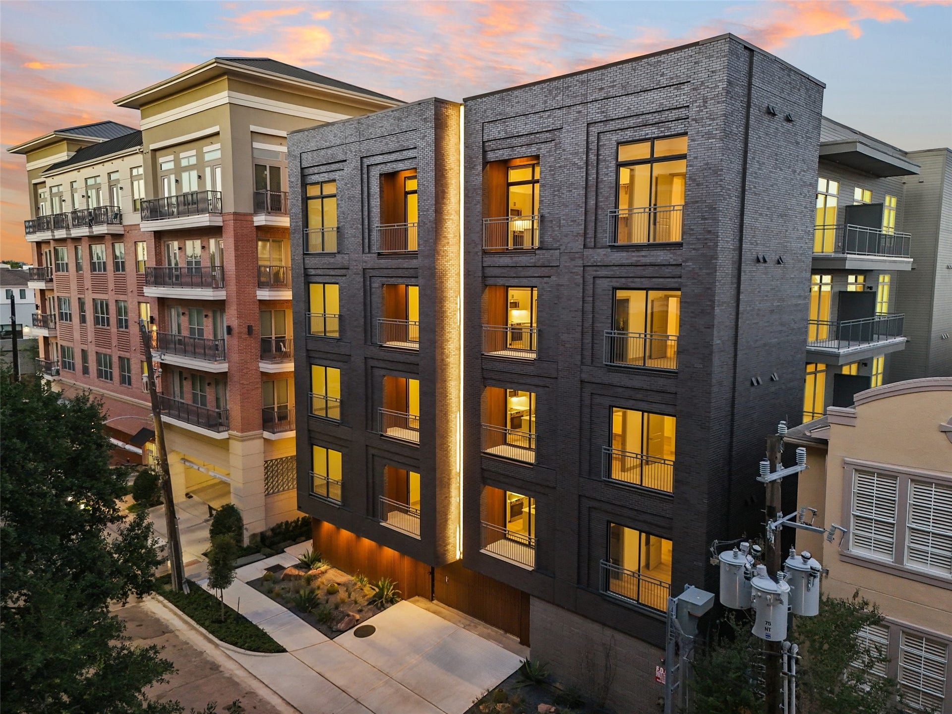 170 Malone Street, #3402, Houston, TX 77007 This photo showcases a modern, multi-story apartment building with sleek architectural design and large, illuminated windows. The exterior features a combination of dark brick and contemporary materials, creating a stylish urban living space.