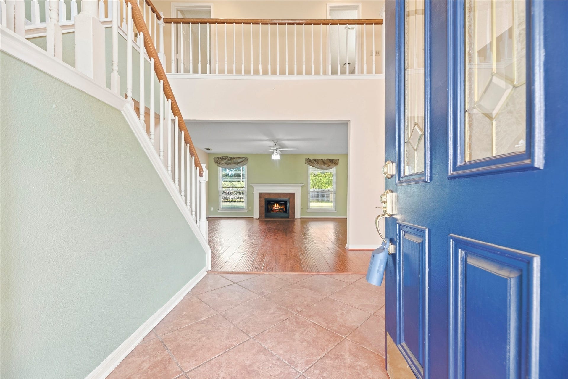 9922 W Cedaredge Drive, Houston, TX 77064 Step into a welcoming foyer with elegant tile flooring, leading to a spacious living area featuring a cozy fireplace and abundant natural light.