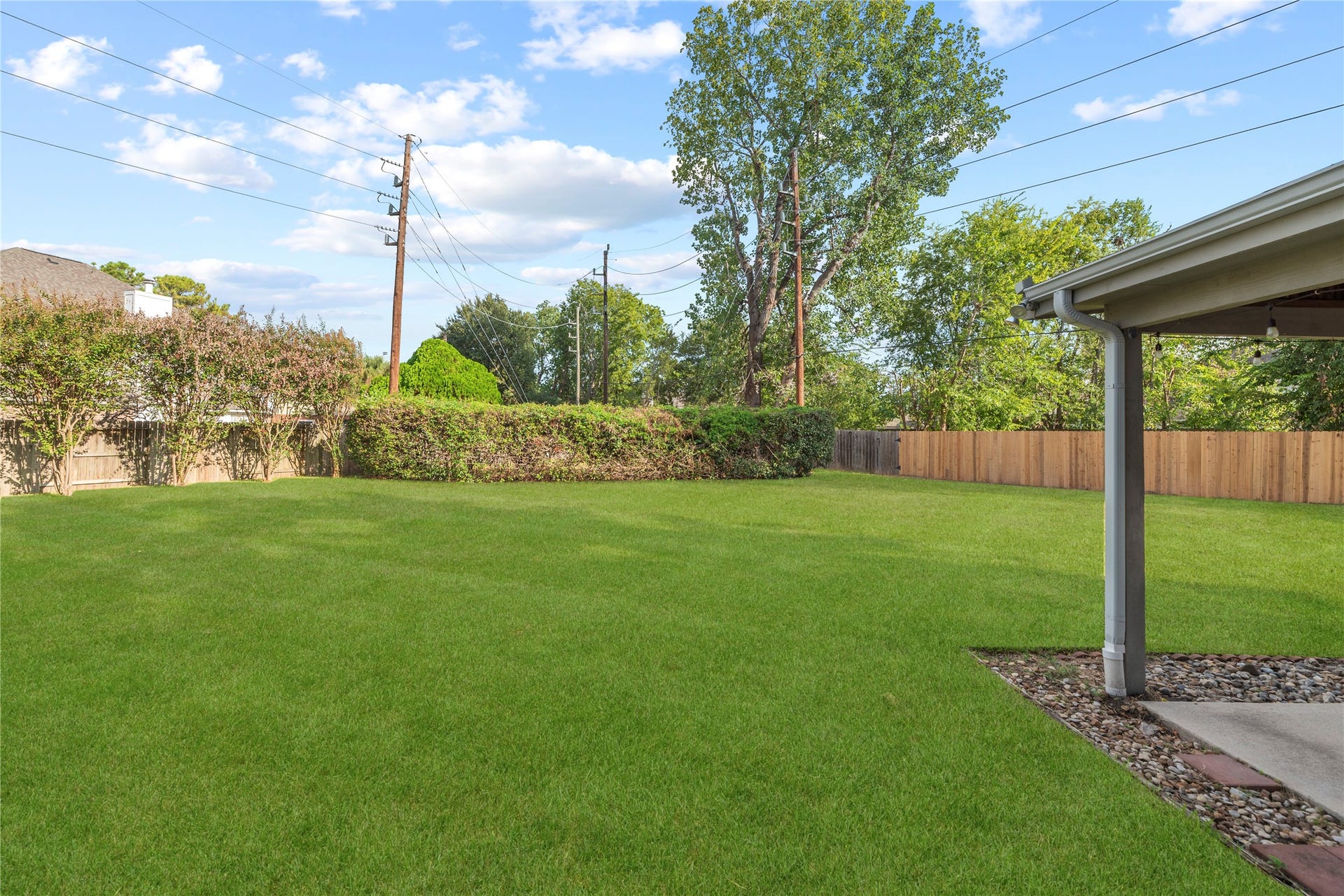 9922 W Cedaredge Drive, Houston, TX 77064 Expansive backyard with lush green lawn, privacy fence, and mature trees, perfect for outdoor activities and relaxation. Plenty of space for an inground pool!