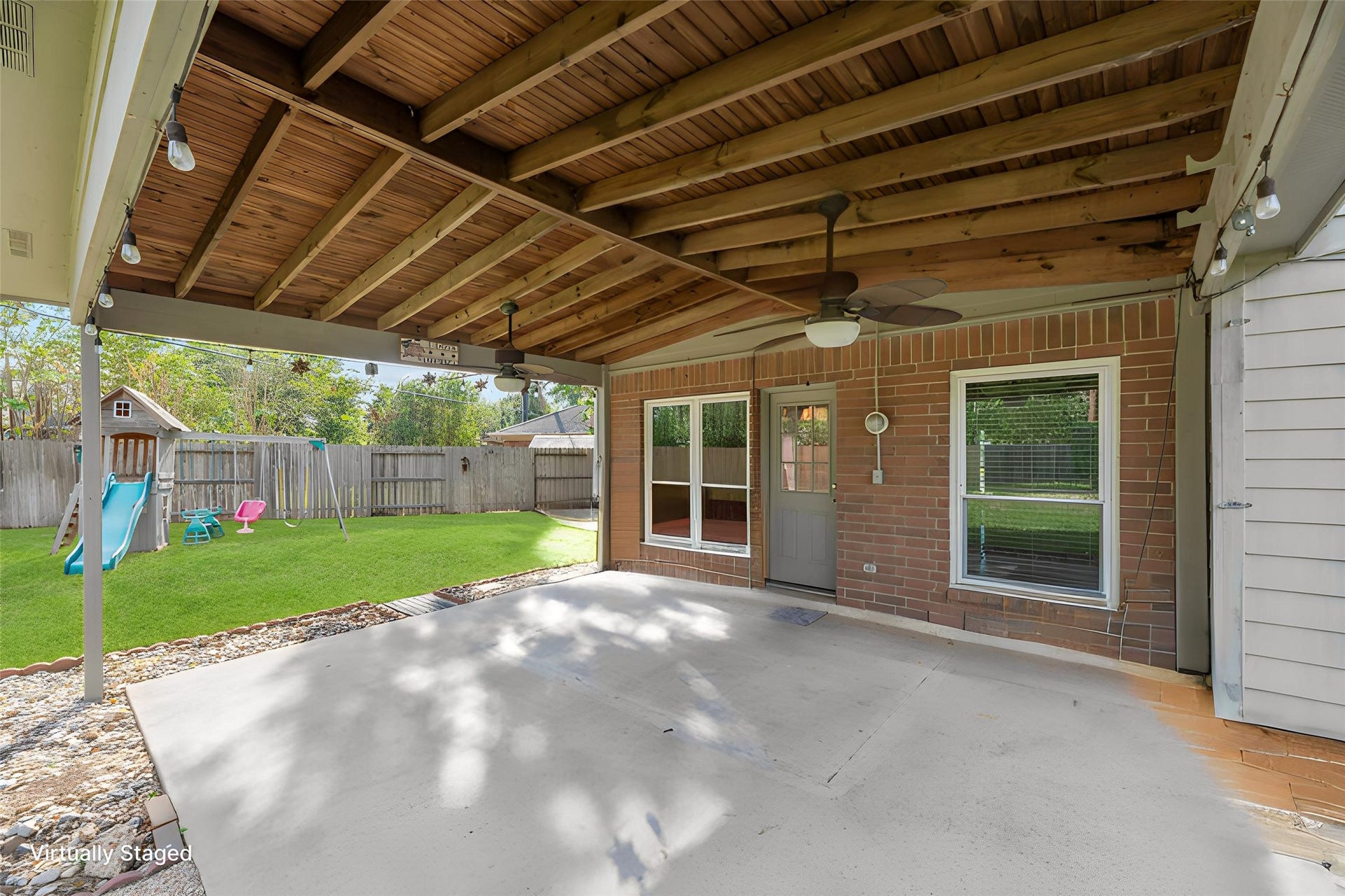 9922 W Cedaredge Drive, Houston, TX 77064 Experience outdoor living at its finest with this covered patio featuring a spacious dining area, perfect for entertaining. Enjoy the backyard playground, ideal for family fun, all within a private fenced setting.