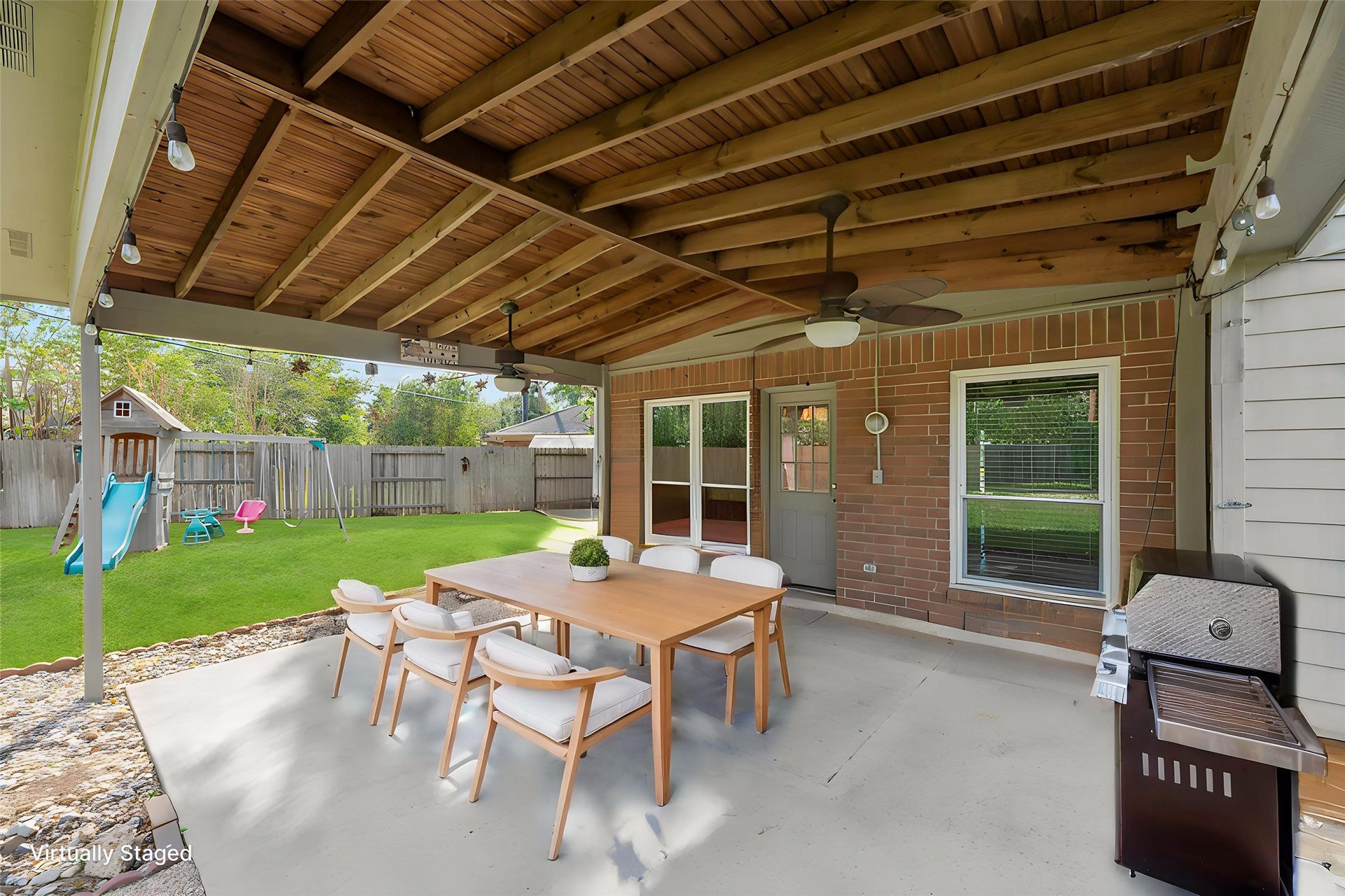 9922 W Cedaredge Drive, Houston, TX 77064 Virtually Staged -- Experience outdoor living at its finest with this covered patio featuring a spacious dining area, perfect for entertaining. Enjoy the backyard playground, ideal for family fun, all within a private fenced setting.