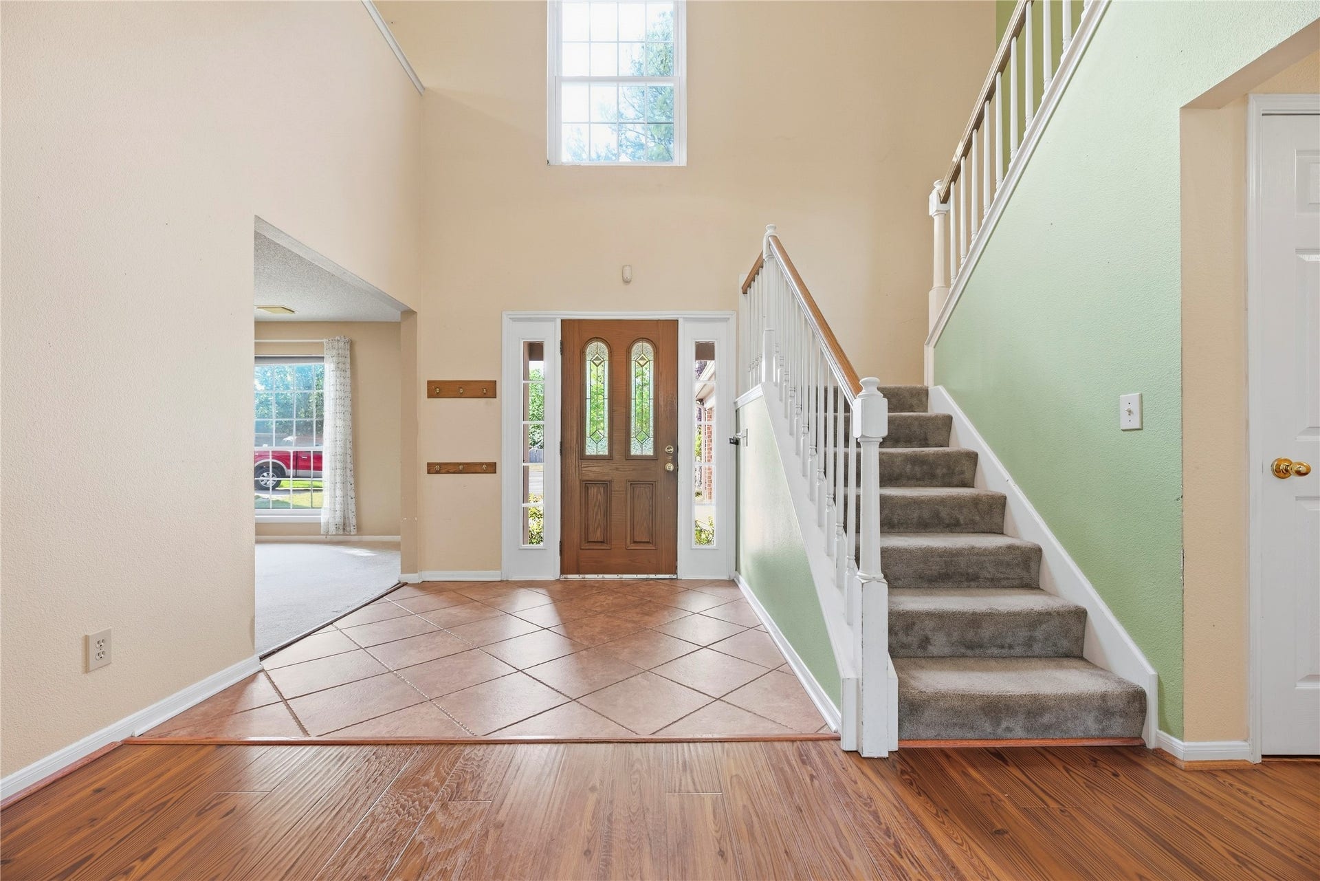 9922 W Cedaredge Drive, Houston, TX 77064 Inviting foyer with high ceilings, abundant natural light, and a staircase leading to the upper level. The warm wood flooring complements the neutral tones, creating a welcoming atmosphere.