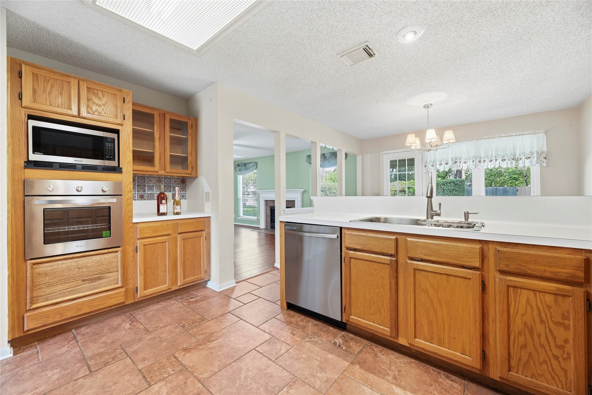 9922 W Cedaredge Drive, Houston, TX 77064 Kitchen offers a convenient pass-through to a bright breakfast area with large windows and backyard views.