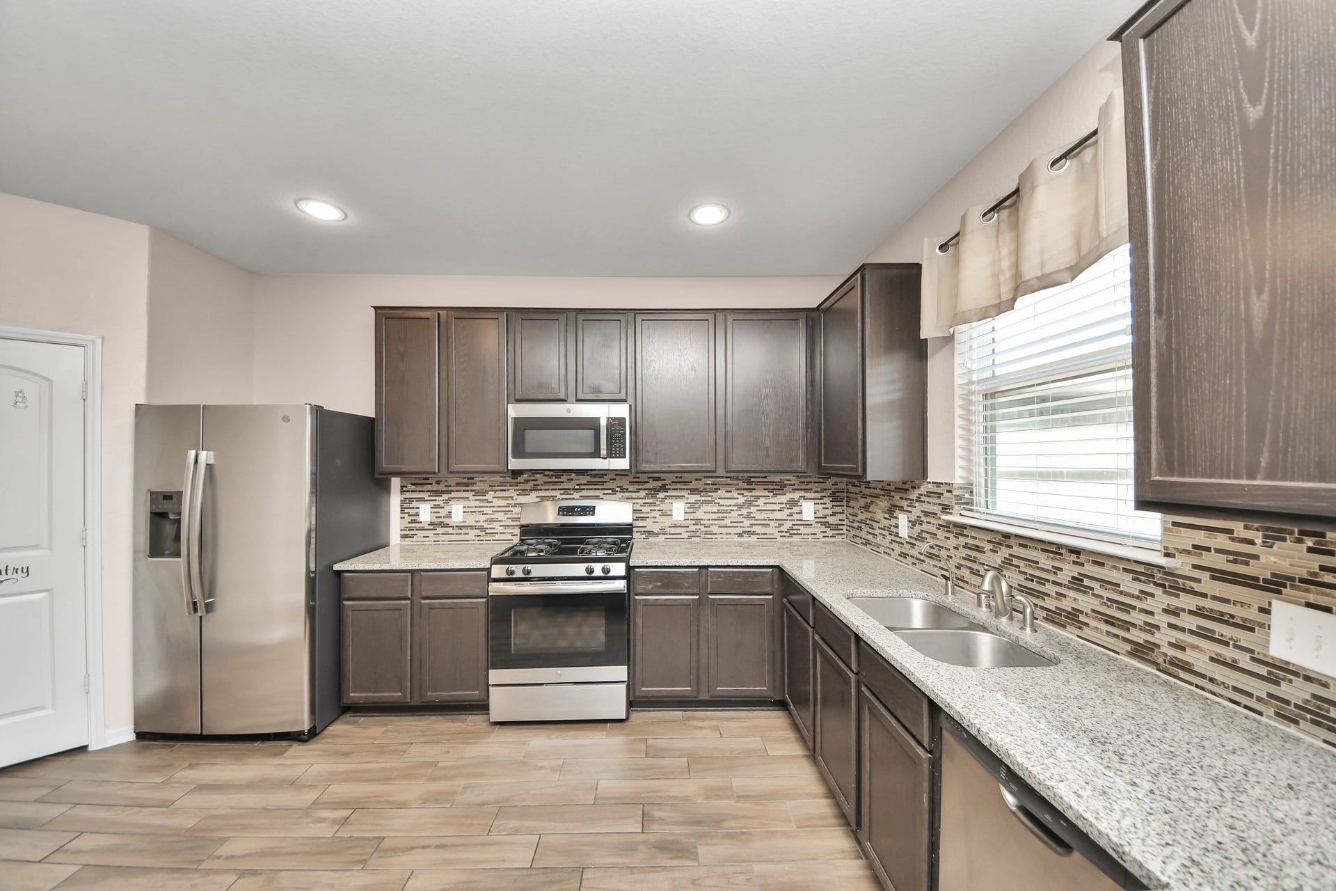 spacious kitchen layout offering plenty of prep space, a gas range, double-basin sink and plenty of natural light.