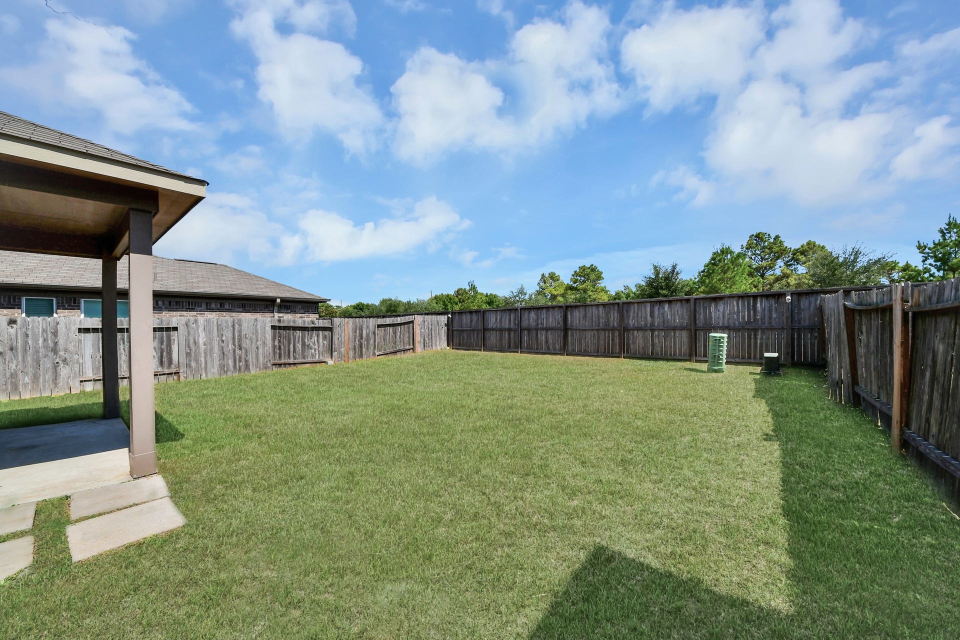 Wide-open backyard provides a blank canvas for a play area, garden, outdoor kitchen or future pool.