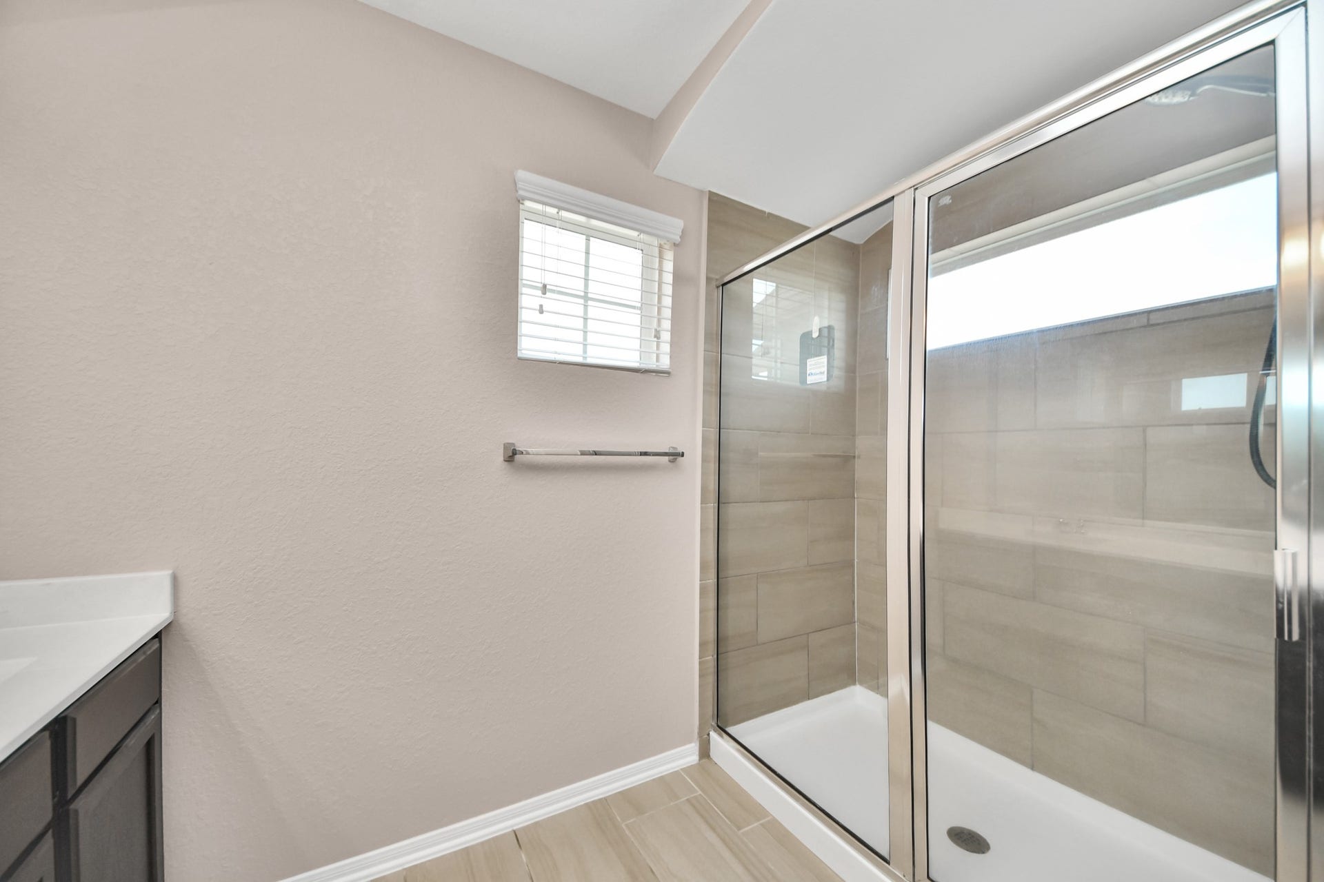 Oversized shower offers a spacious interior, tiled surround and sleek sliding-glass enclosure.