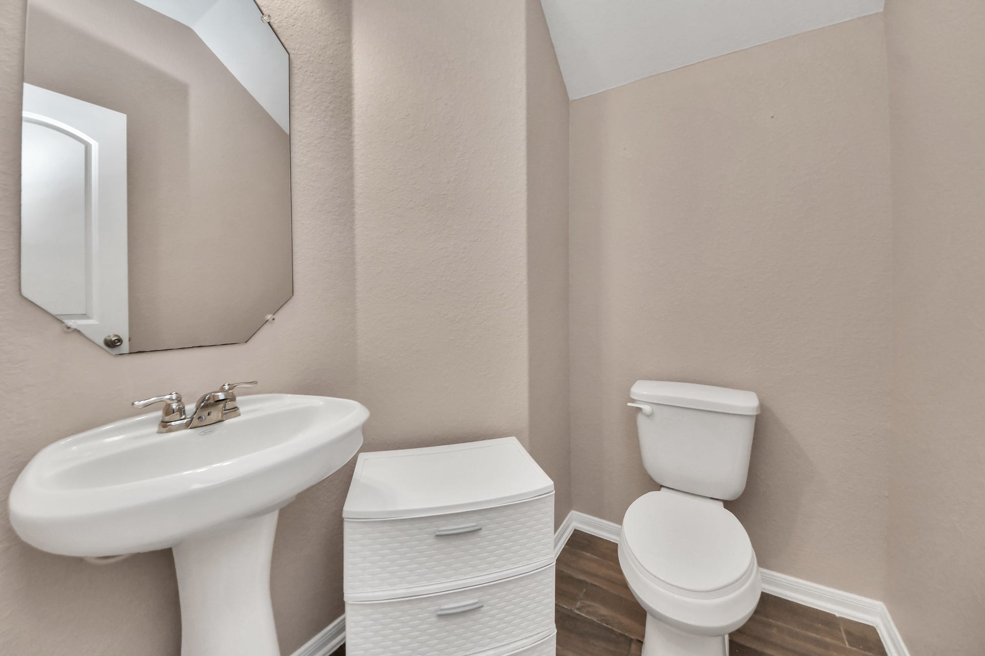 Convenient and spacious downstairs half bath with a pedestal sink.