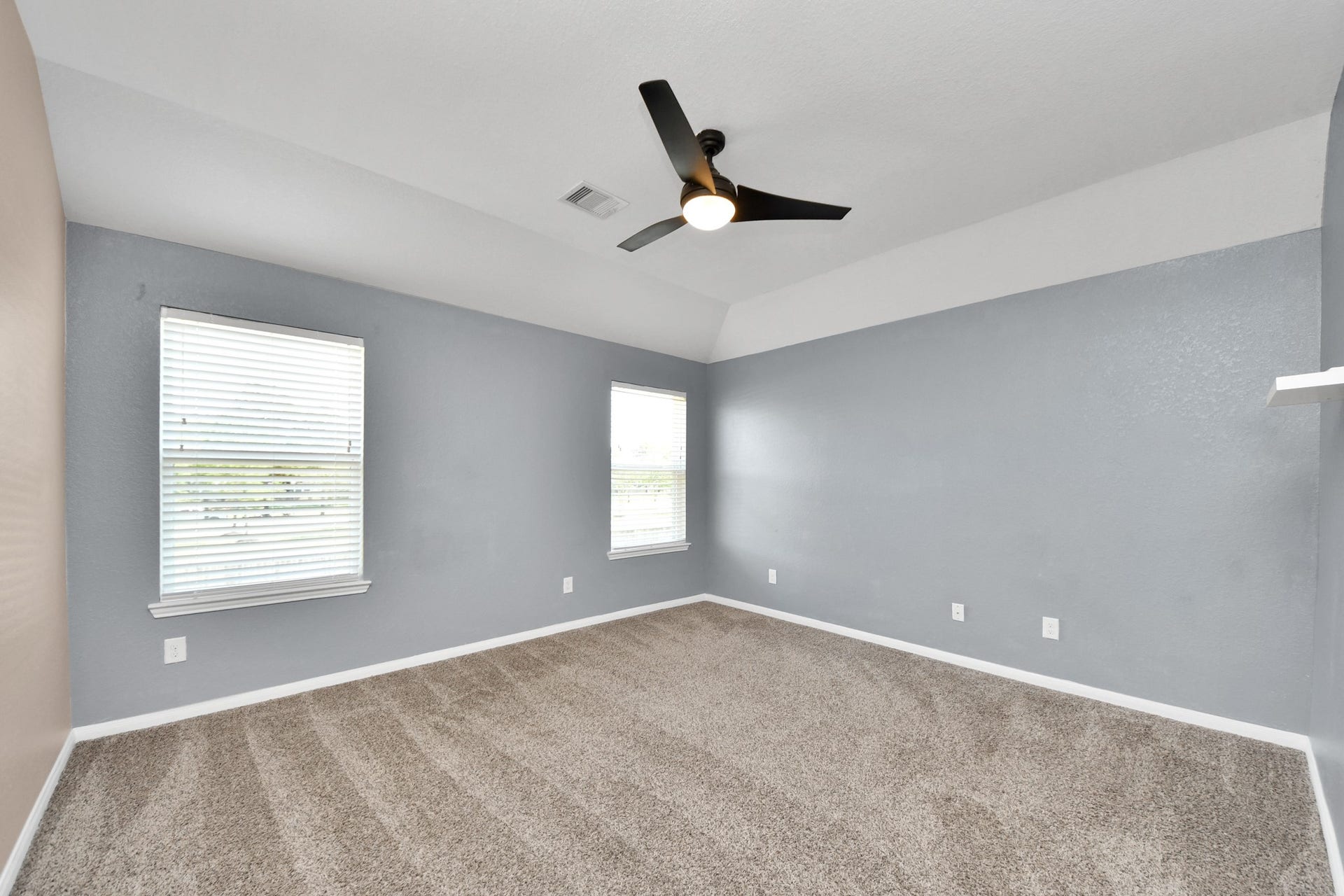 Spacious game/flex room with a tray ceiling and abundant natural light, ready for a media room, play area, home office or hobby space.