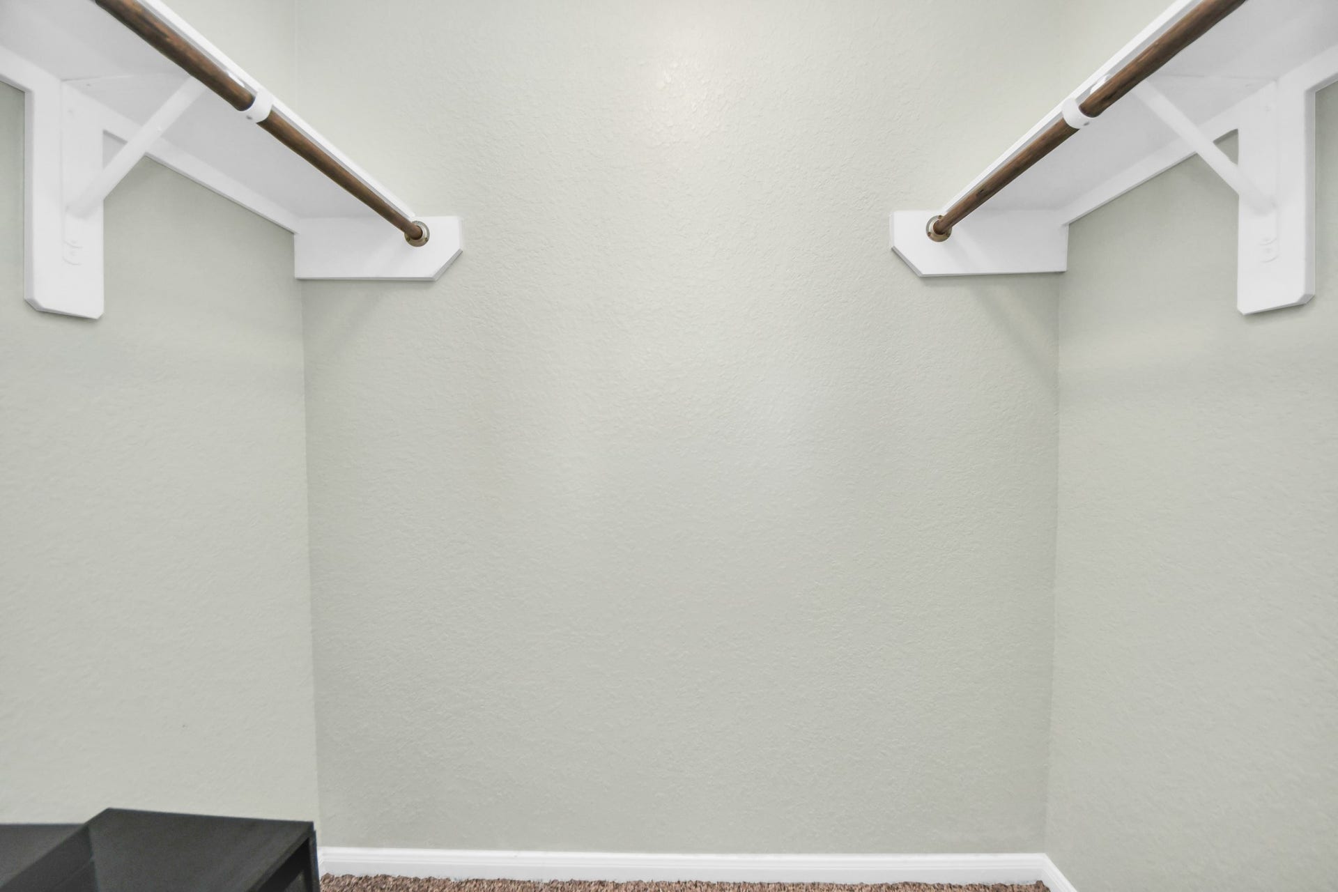 Third-bedroom closet provides generous storage with hanging rods and shelving on both sides.