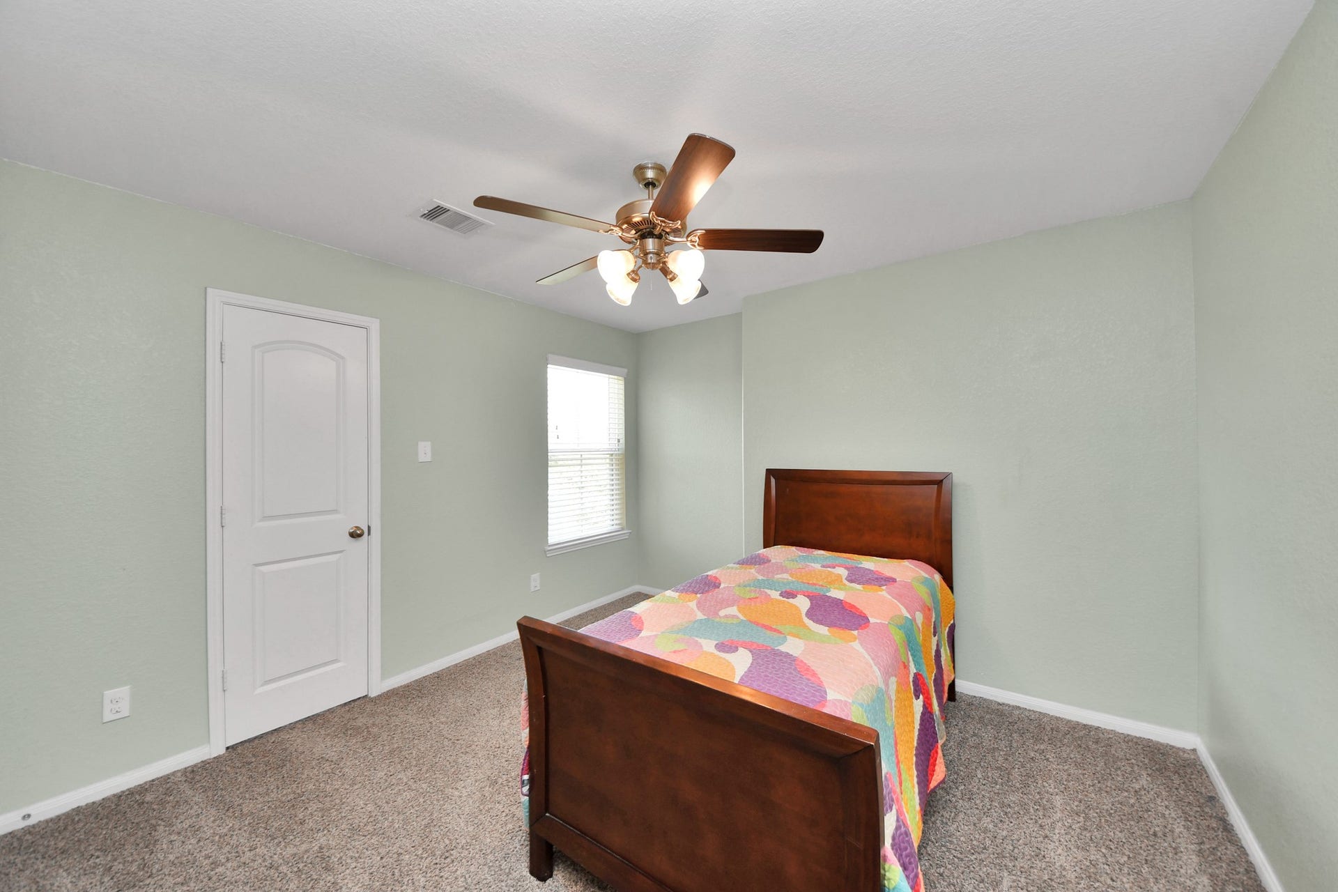 Bright and inviting secondary bedroom offers plenty of space to create a comfortable private retreat, complete with a closet and ceiling fan.
