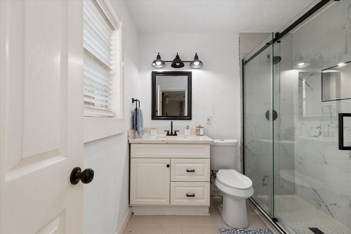 215 Caplin Street, Houston, TX 77022 Downstairs unit bathroom with updated vanity and walk-in shower.