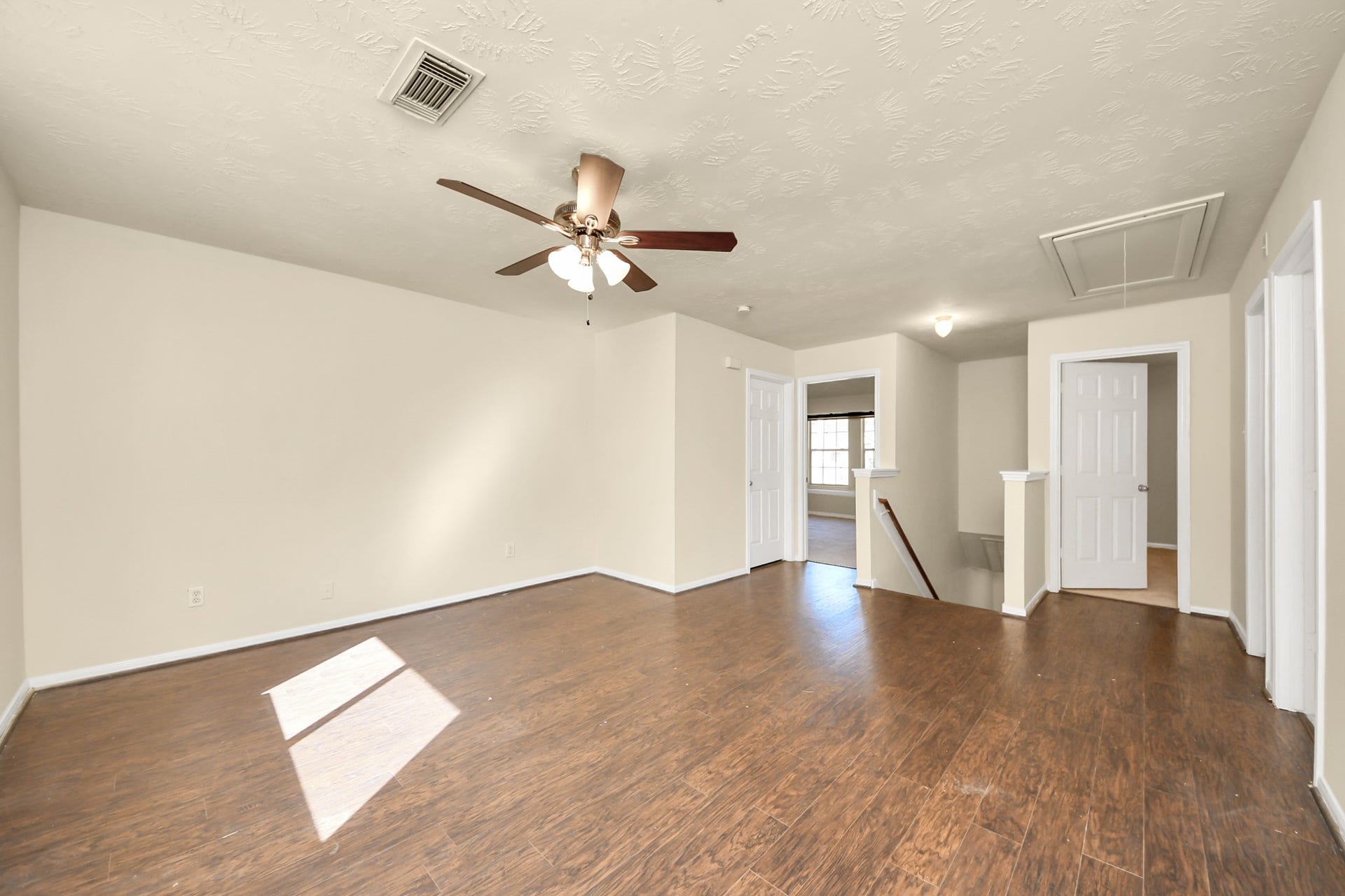 Large upstairs flex space living area with brand new neutral paint, ceiling fan and abundant natural light.