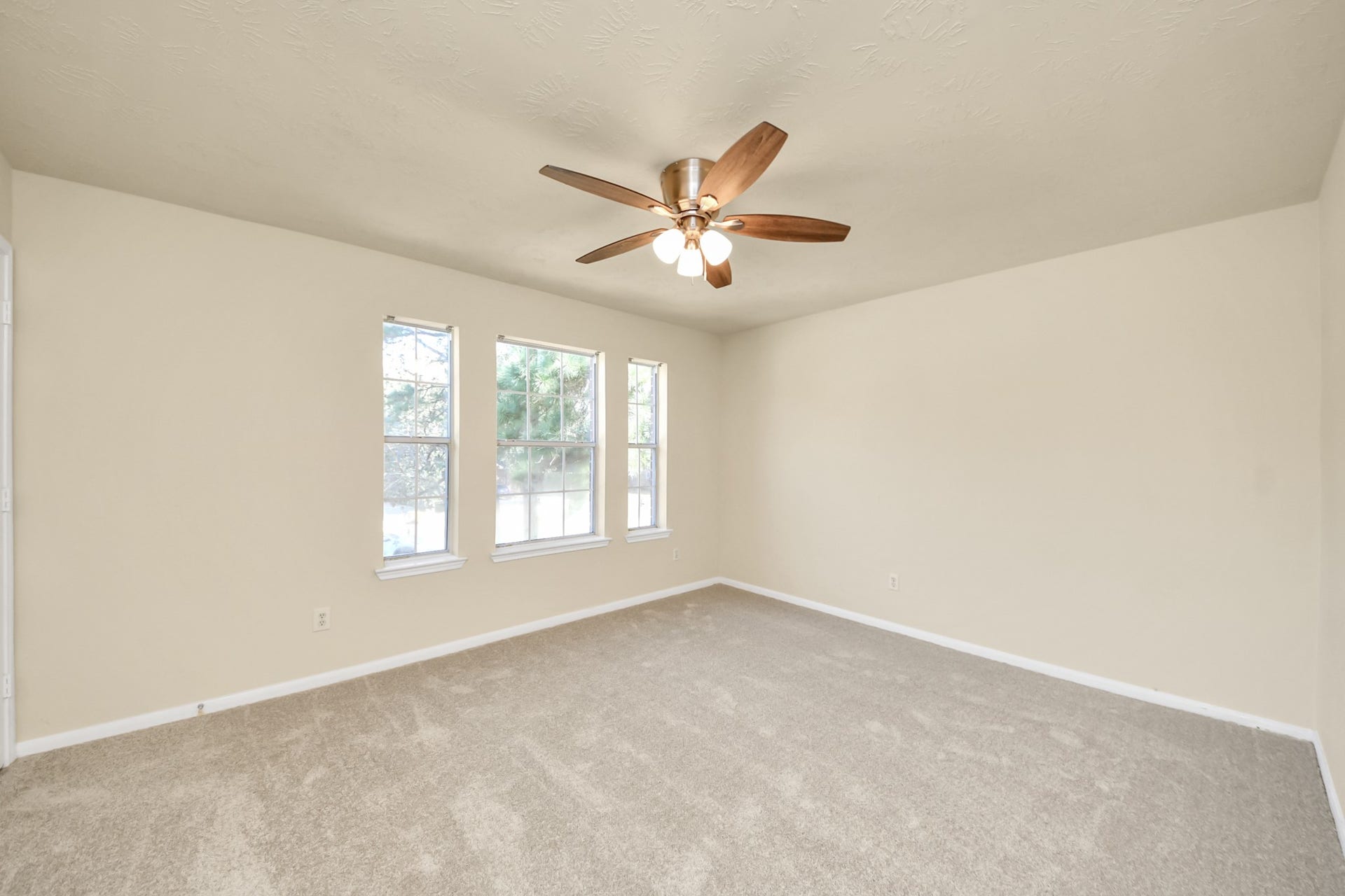 Another secondary bedroom with ceiling fan and large window.
