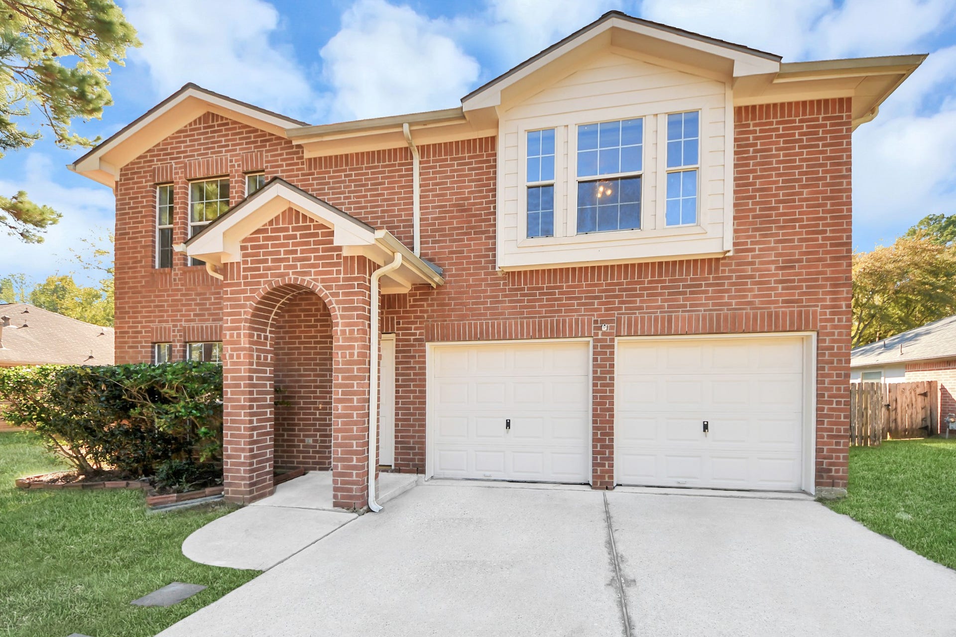Spacious two-story brick home with arched entryway, two-car garage, extended driveway and large lot.