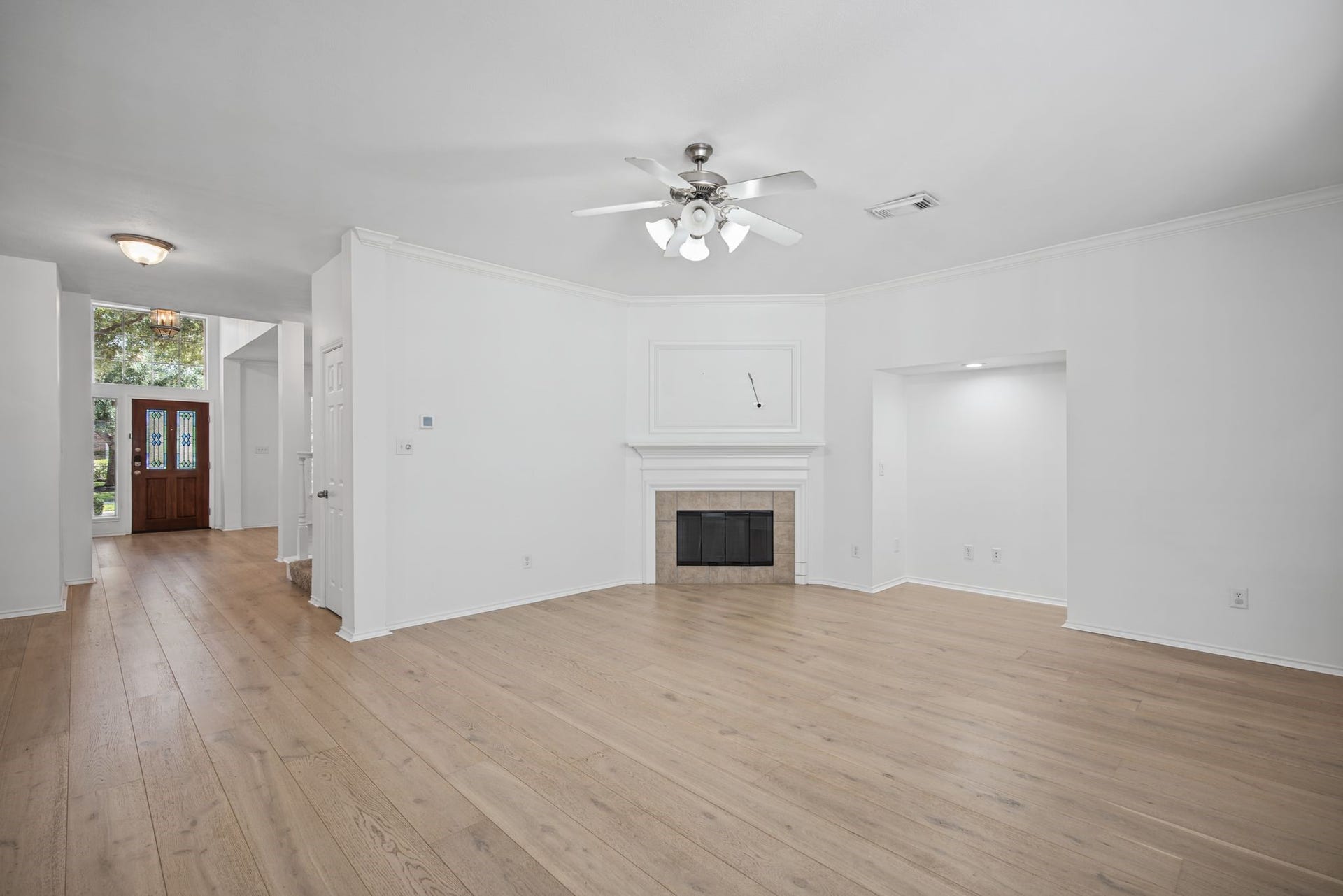 This perspective reveals the connection to the entry hall and the architectural recess beside the fireplace.