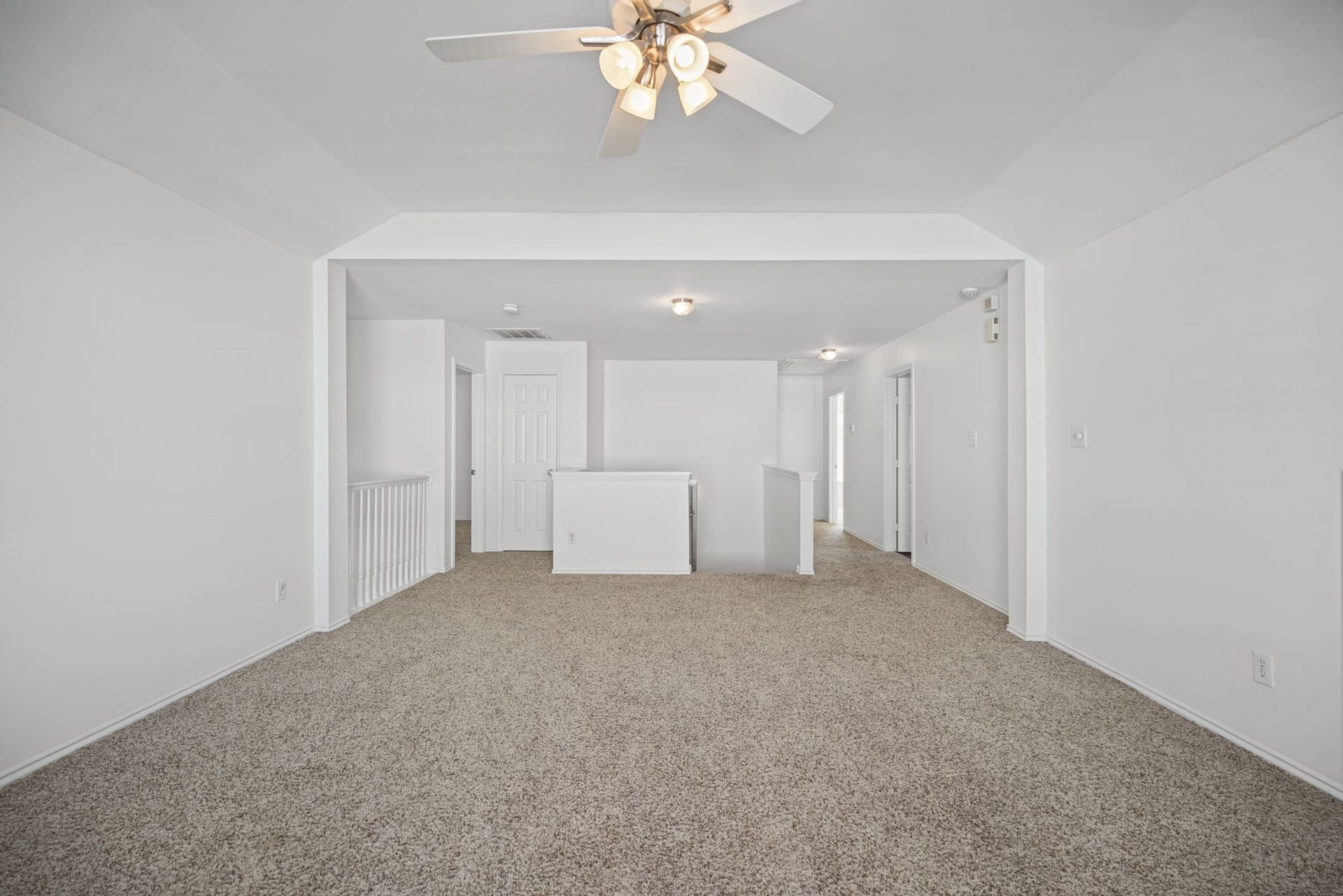 As you head upstairs, the spacious game room offers an inviting extension of the homes living areas, with carpeted flooring and an open connection to the stair landing.
