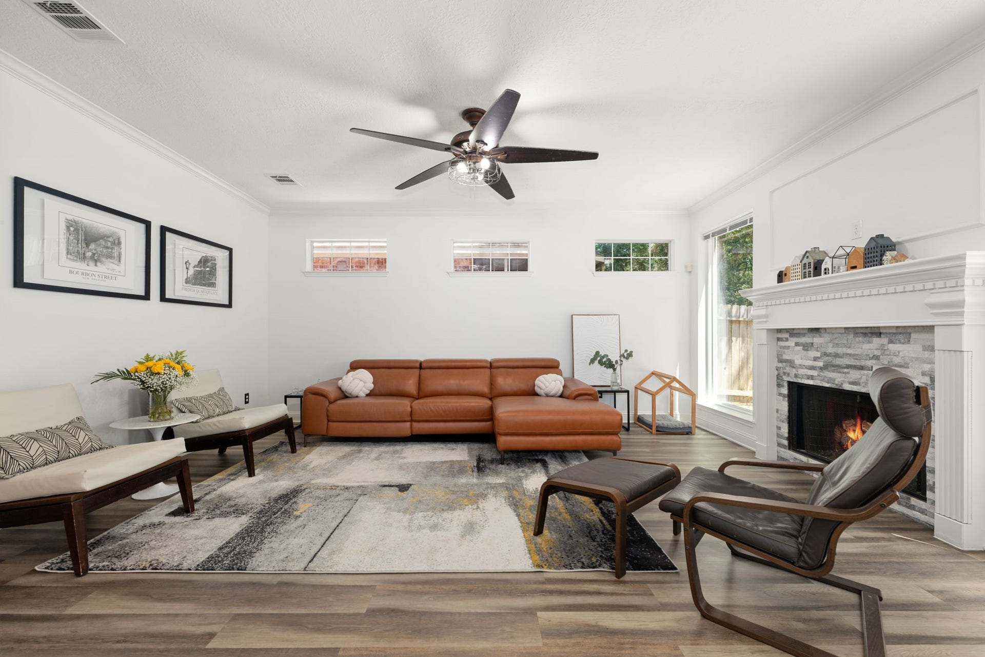 Bright and inviting living room featuring a cozy fireplace, elegant crown molding, and stylish wood flooring, perfect for relaxation and gatherings.