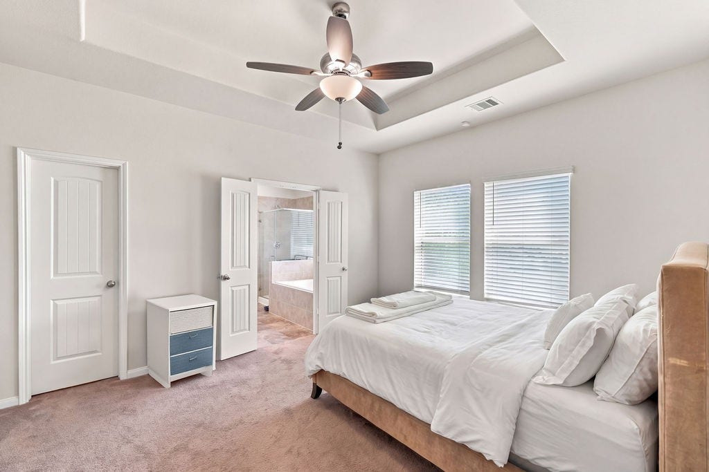 6623 Blimp Base Blvd, Hitchcock, TX 77563 Virtually staged primary bedroom and bathroom with large closet space.