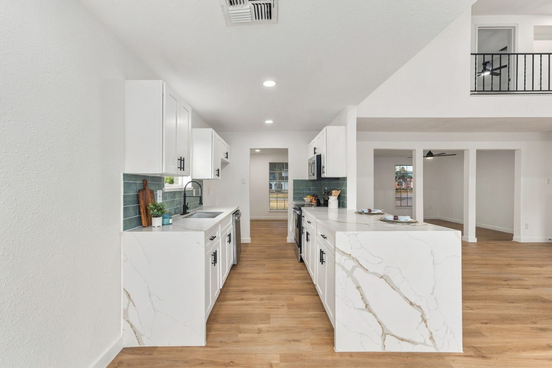 Beautifully updated kitchen featuring quartz waterfall countertops and custom white cabinetry.