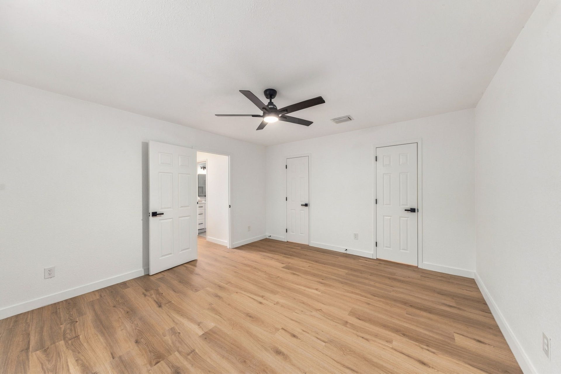 Spacious primary suite with updated flooring, fresh paint, oversized closet and updated ceiling fan.