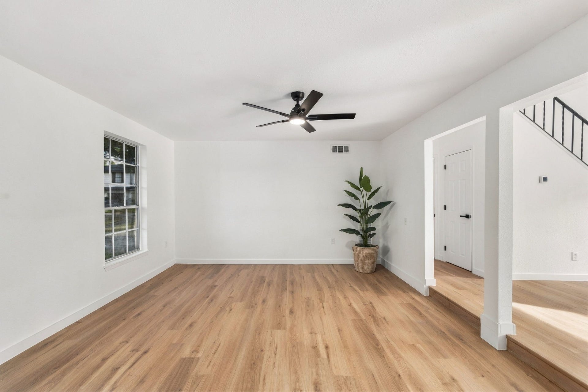 Sunken formal living room with new flooring, fresh paint, and updated ceiling fan.
