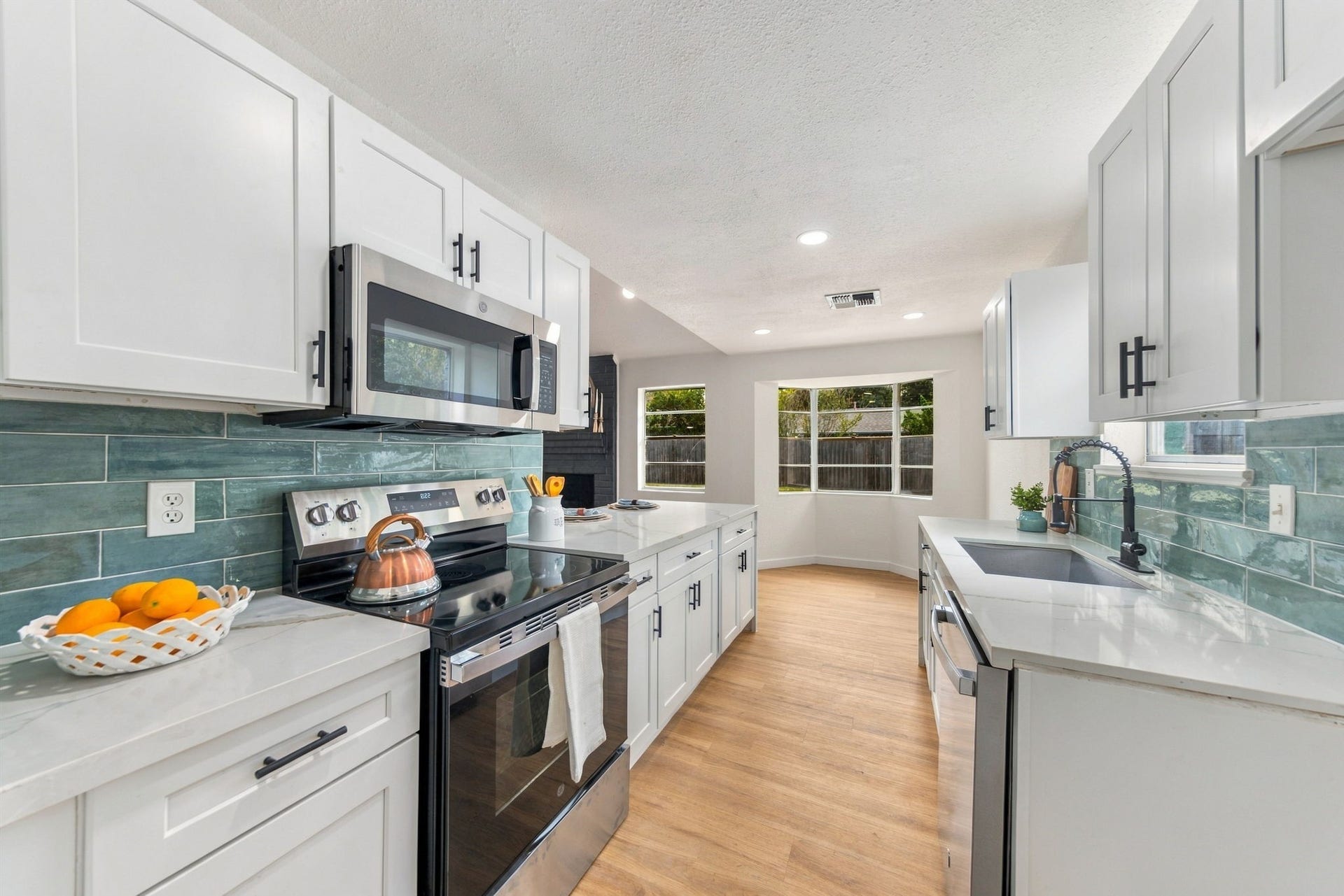 New stainless steel appliances, tile backsplash, and updated black hardware.