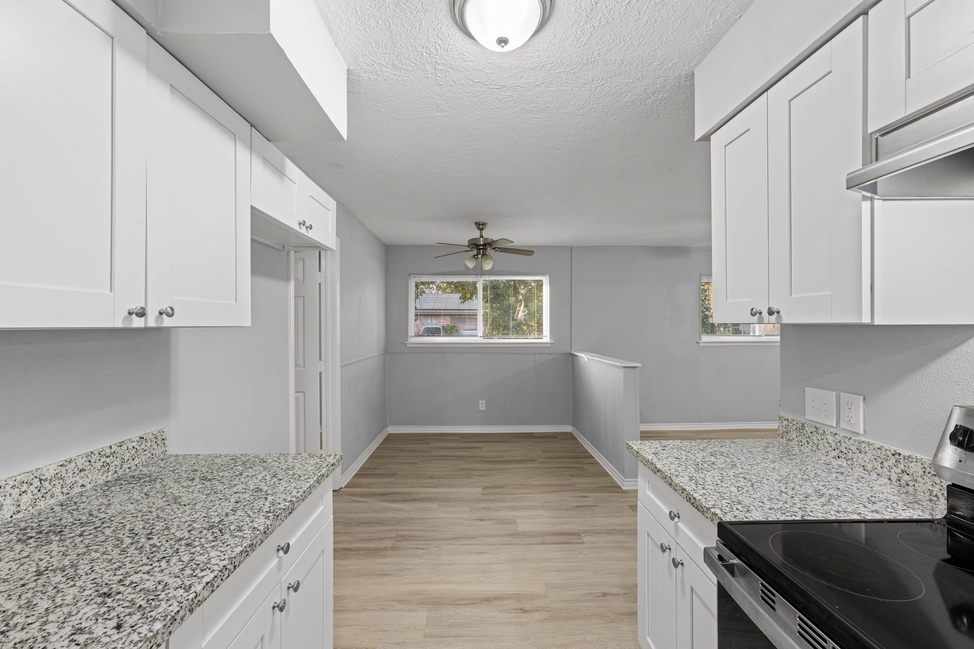 4802 Hannas Reef Drive, Bacliff, TX 77518 Enjoy the easy flow between the updated kitchen and adjoining dining area, featuring wood-look flooring, abundant natural light, and a ceiling fan for added comfort.