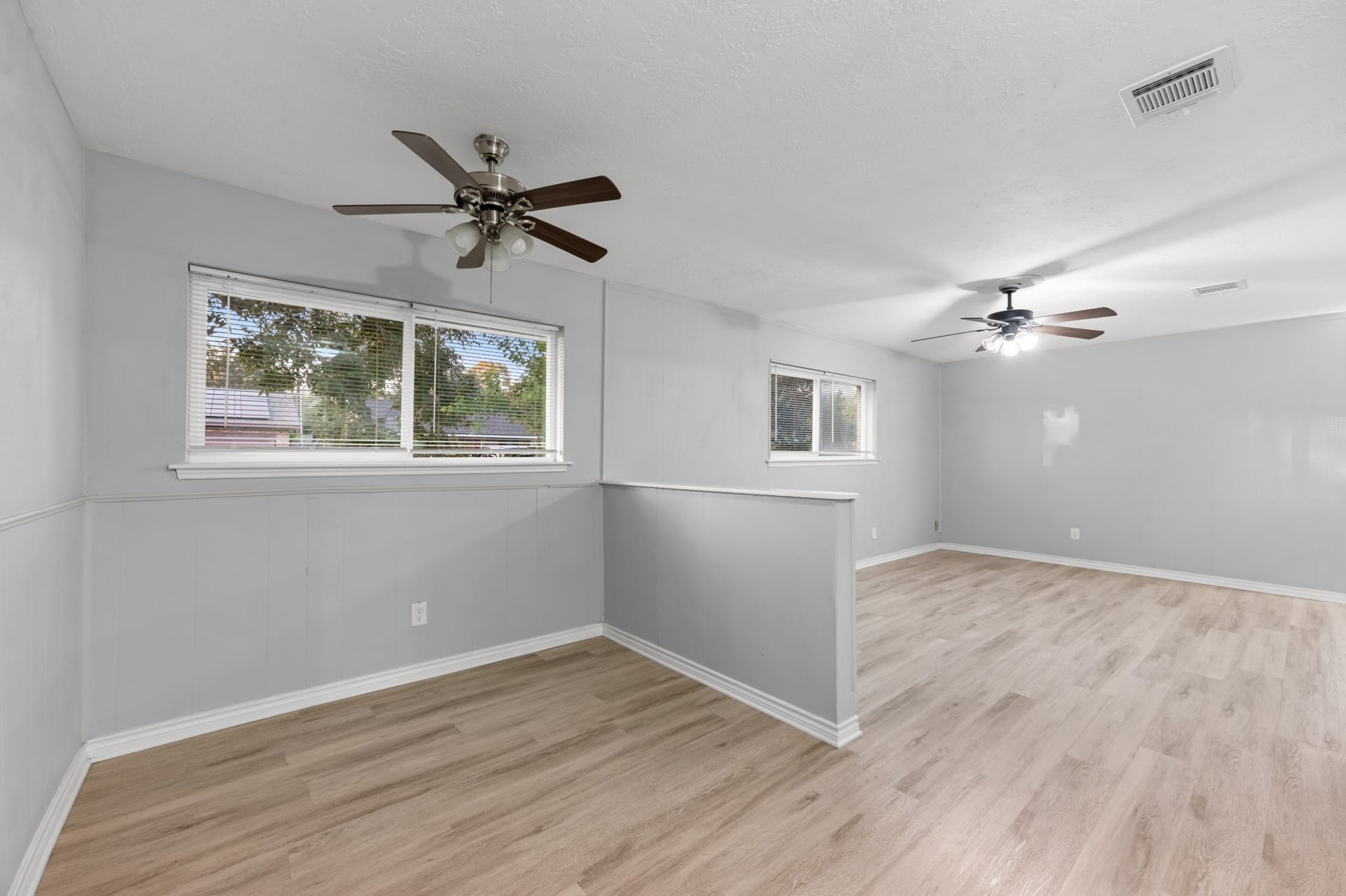 4802 Hannas Reef Drive, Bacliff, TX 77518 The adjoining living and dining spaces are thoughtfully defined by a partial-height wall while maintaining an open feel, with windows bringing natural light into both areas.