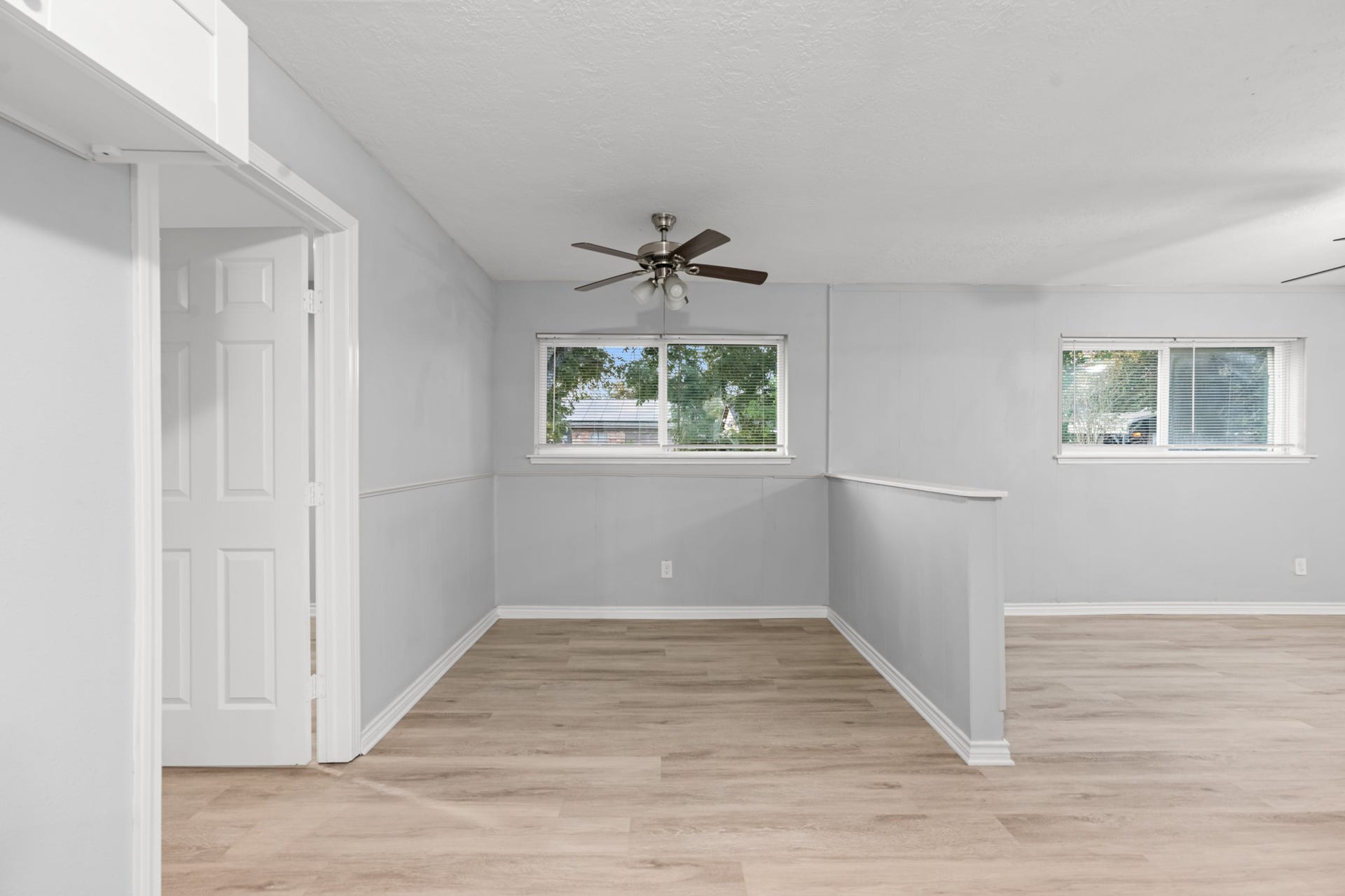 4802 Hannas Reef Drive, Bacliff, TX 77518 The dedicated dining area features classic wainscoting, a ceiling fan, and a large window, offering a welcoming space for everyday meals and gatherings.