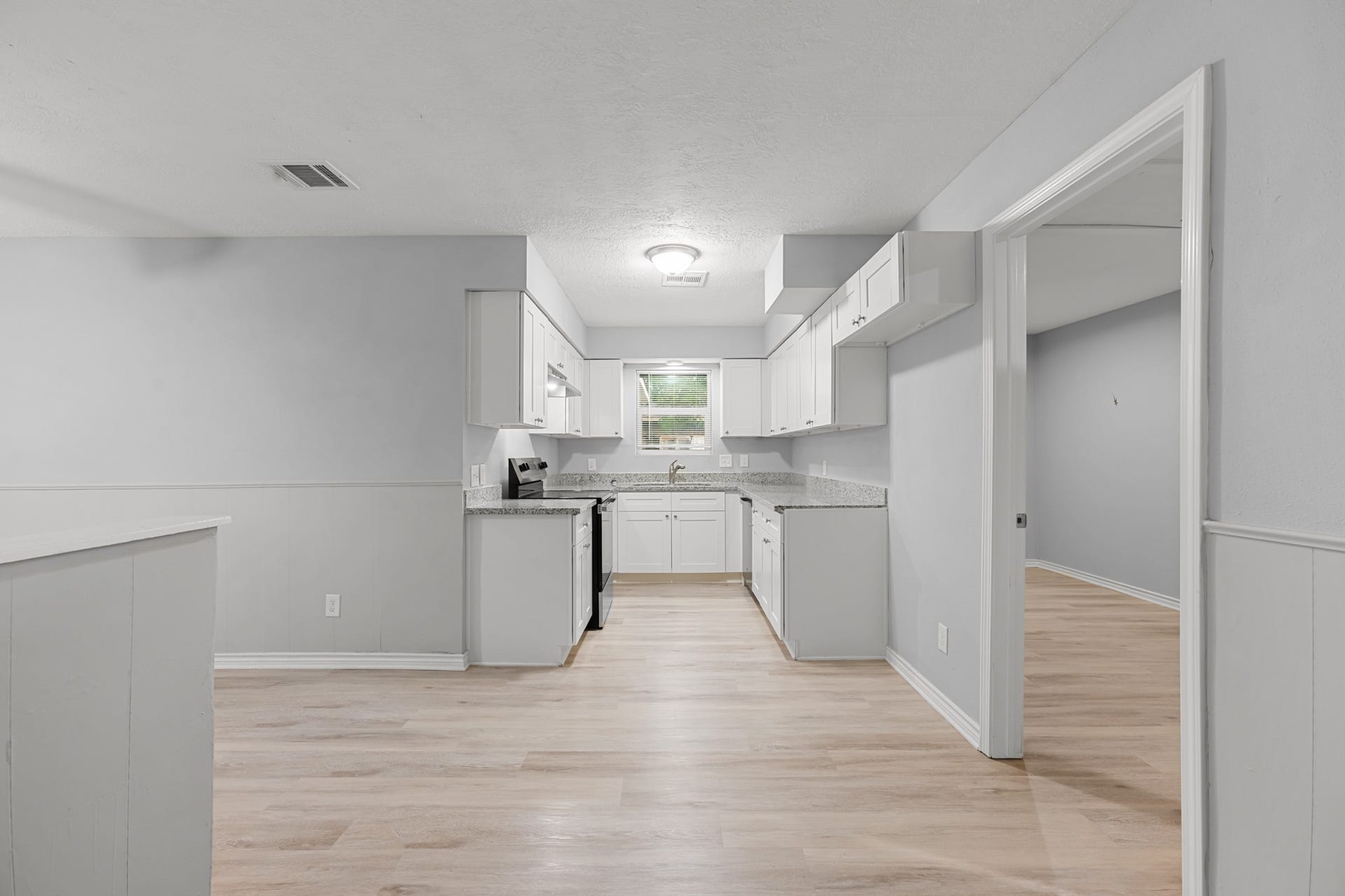 4802 Hannas Reef Drive, Bacliff, TX 77518 The updated galley-style kitchen features crisp white shaker-style cabinetry, granite countertops, stainless steel appliances, and wood-look flooring. Generous counter space and cabinetry provide functionality for everyday cooking and entertaining.
