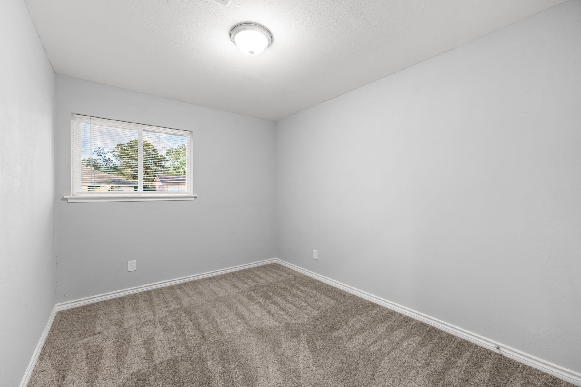 4802 Hannas Reef Drive, Bacliff, TX 77518 Another bedroom highlights the clean, neutral finishes, generous wall space for furniture placement, and natural light from the window.