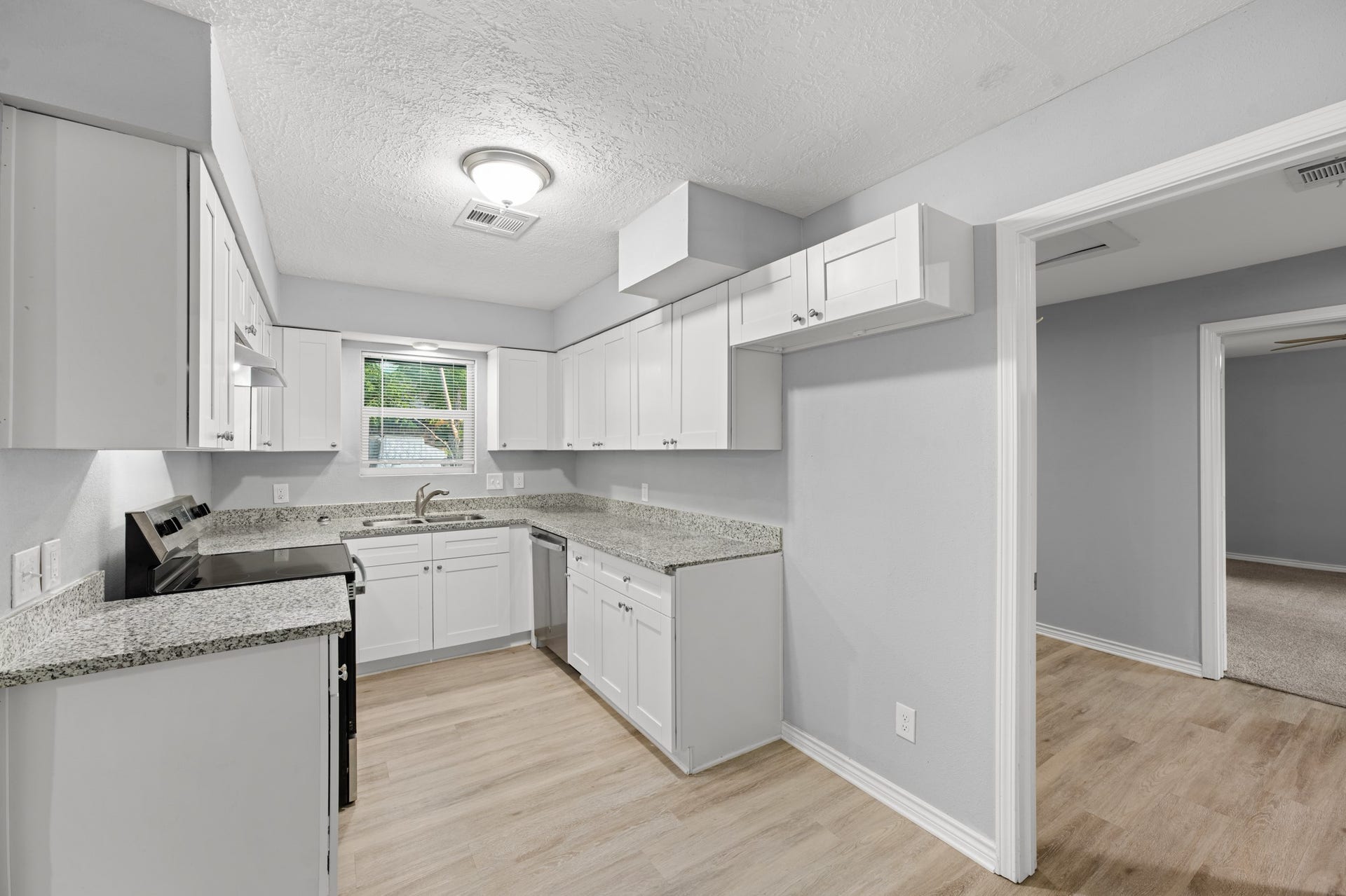 4802 Hannas Reef Drive, Bacliff, TX 77518 Another view of the updated kitchen highlights the wraparound granite countertops, stainless steel appliances, and convenient access to the adjoining rooms.