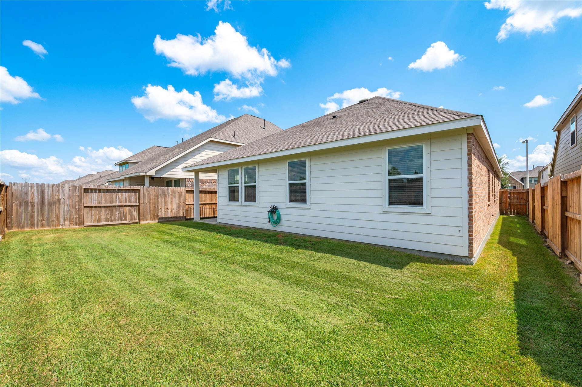 1849 Kenley Way, Alvin, TX 77511 Spacious backyard with well-maintained lawn and new privacy fencing, perfect for outdoor activities and entertaining.