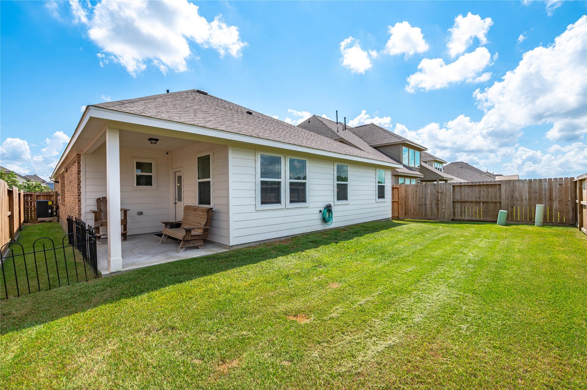 1849 Kenley Way, Alvin, TX 77511 The private backyard with a well-maintained lawn and a cozy covered patio, perfect for outdoor relaxation and entertaining.