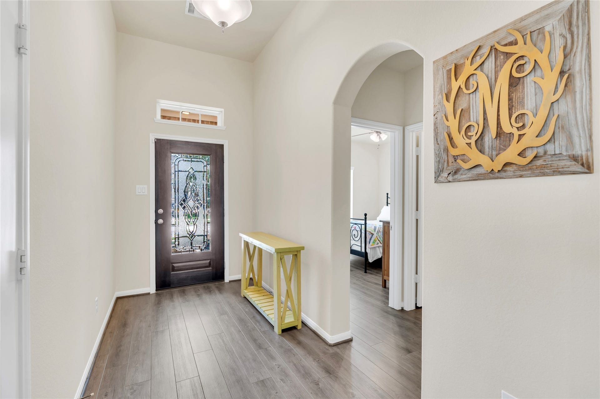 1849 Kenley Way, Alvin, TX 77511 Inviting entryway with elegant dark wood flooring, a decorative glass front door, and a charming archway leading to the living spaces.