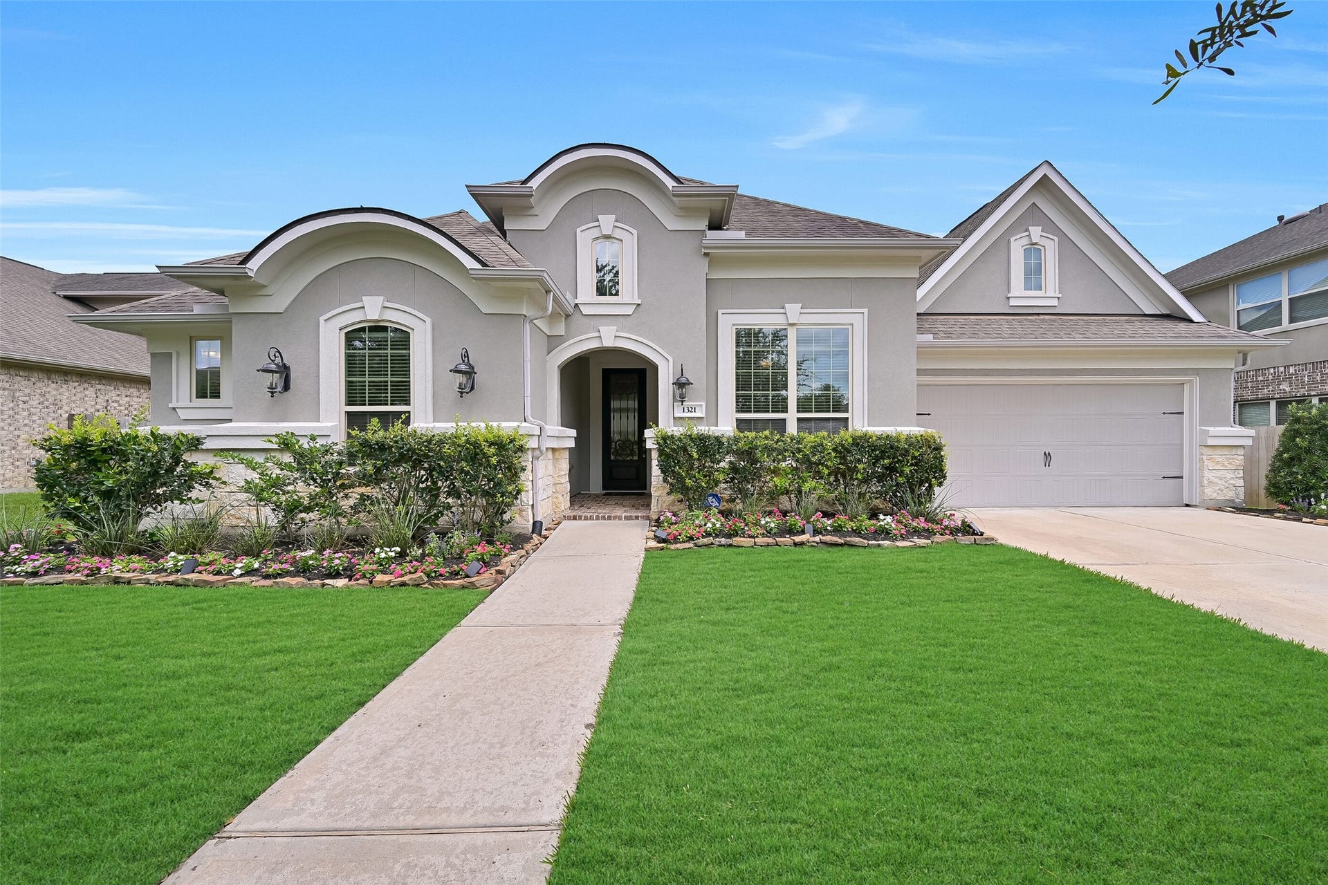 Located in the gated Arbor Gate section of West Ranch, this beautiful Village Builders home showcases timeless stucco and stone architecture, manicured landscaping, mature oak trees, solar landscape lighting, carriage lanterns, and a double-wide driveway leading to a tandem 3-car garage.