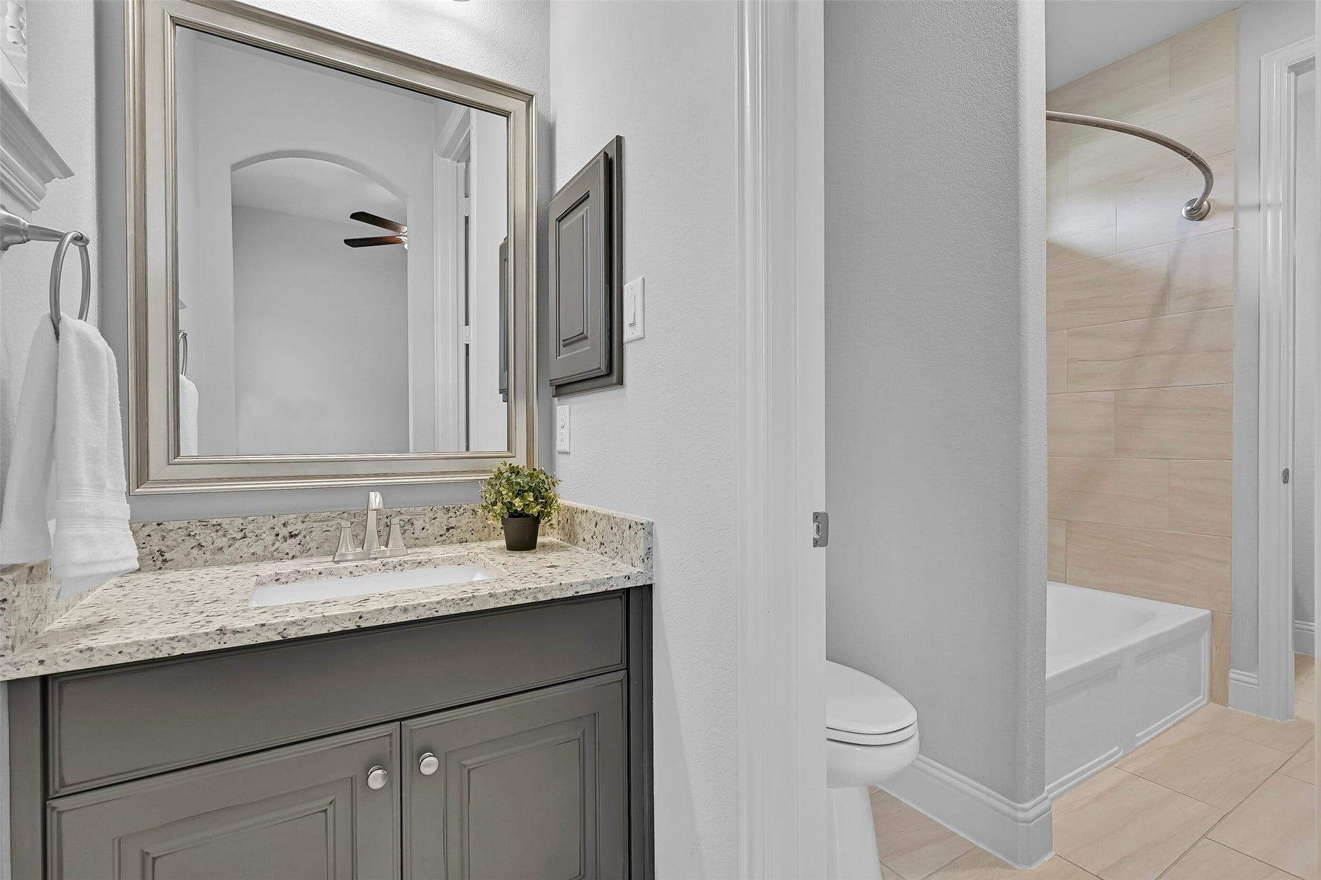 An alternate view highlights the shared design, complete with granite countertops, ample storage, and a private tub/shower area finished with oversized tile surround. Ideal for busy households, the layout provides both functionality and convenience.