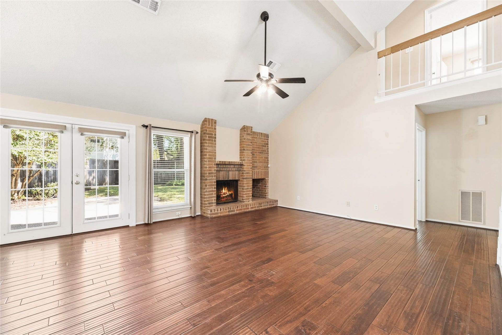 The family room offers beautiful wood flooring and a cozy fireplace with brick surround.