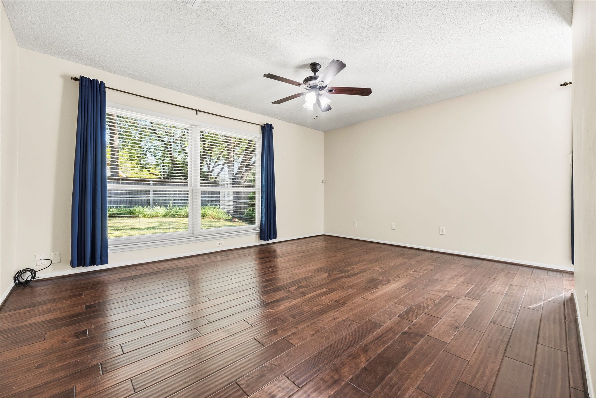 Primary bedroom with wood flooring, ceiling fan and en-suite bathroom.