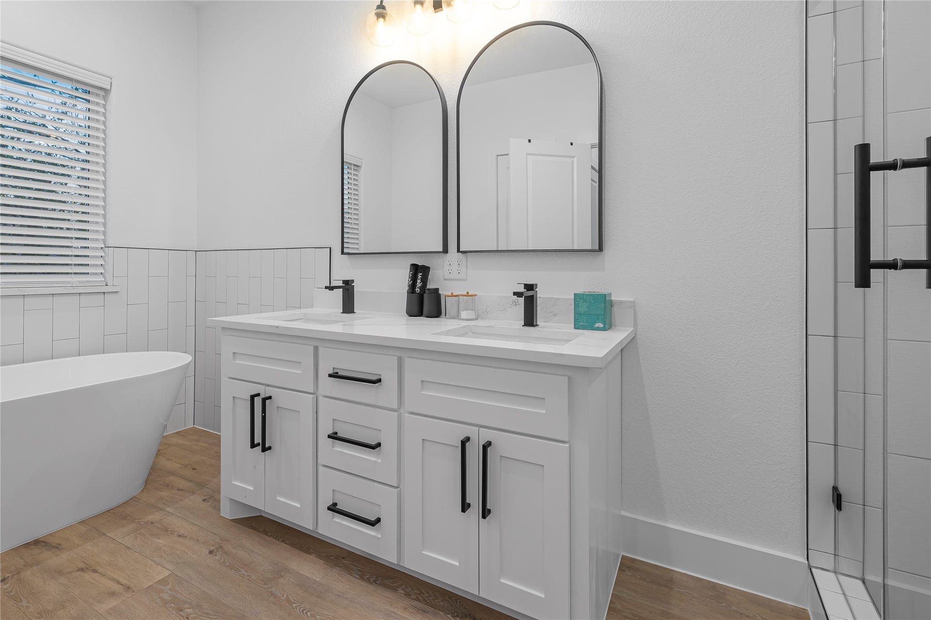 7107 Foster Street, #B, Houston, TX 77021 Elegant bathroom with a modern double vanity, stylish black fixtures, and a luxurious freestanding tub.