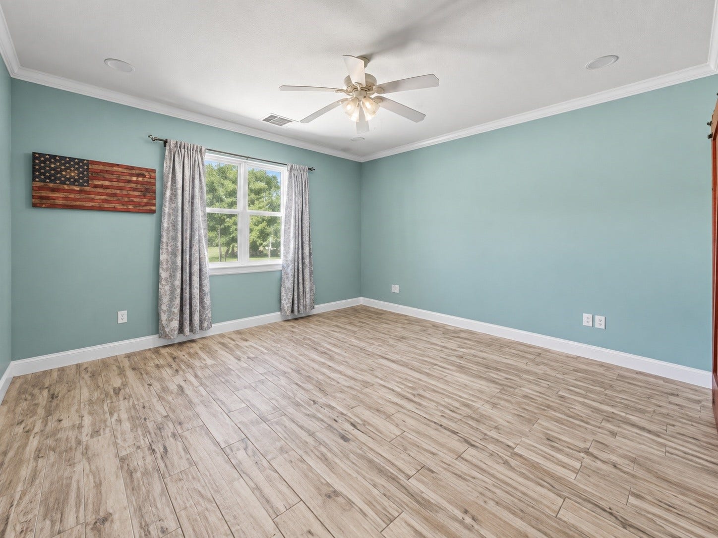 Primary bedroom featuring generous space, crown molding, ceiling fan, and plenty of natural light
