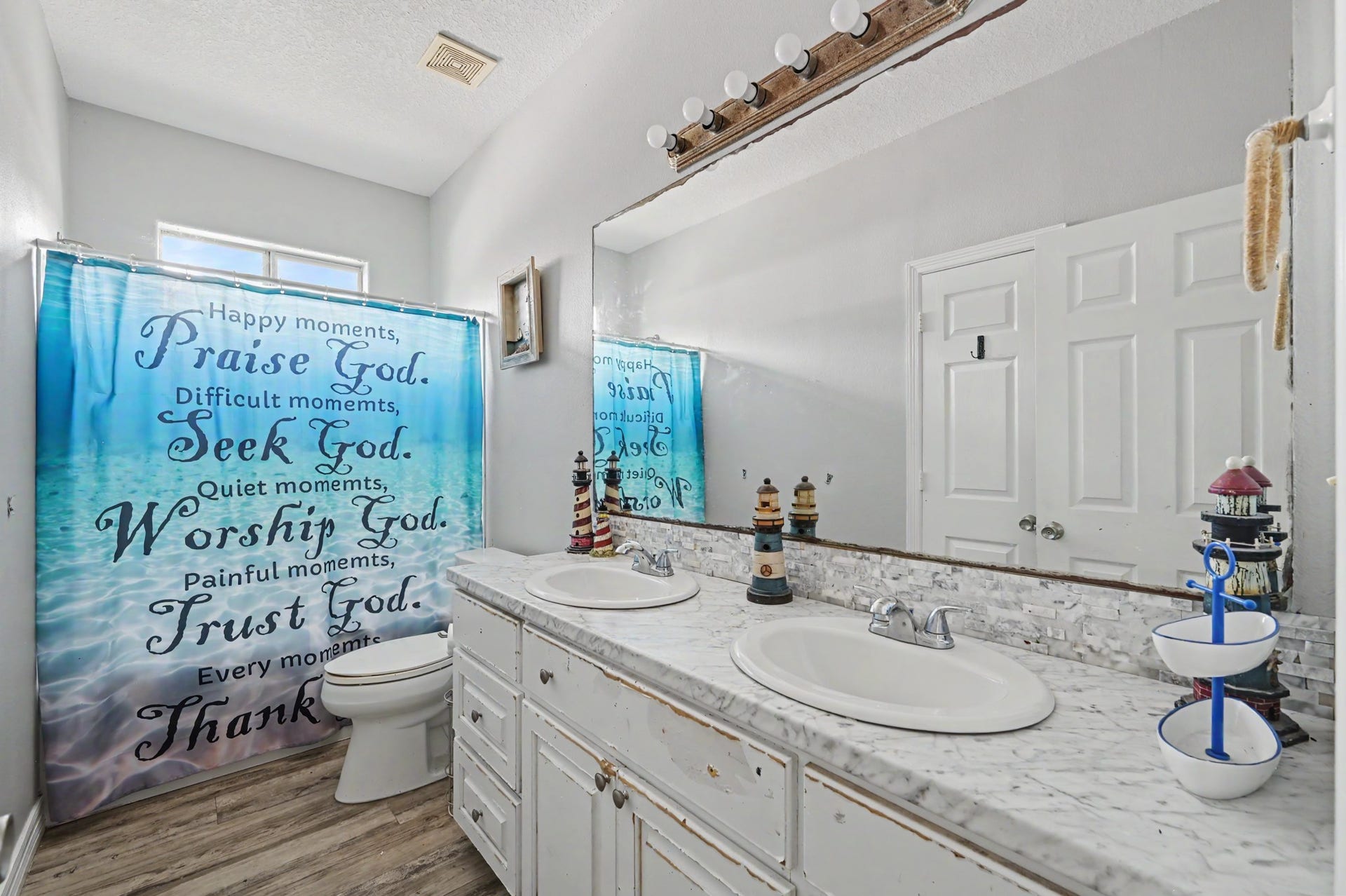 Secondary bathroom featuring a large vanity, expansive mirror,  tub/shower combination, and ample counter space.