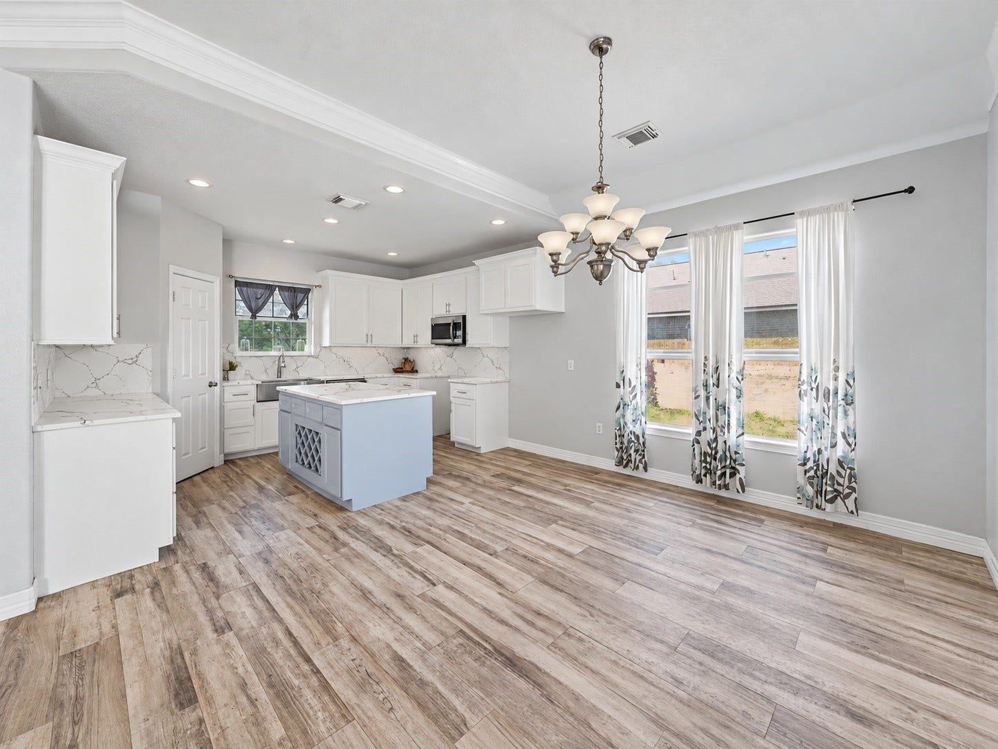 Open kitchen and dining area featuring abundant natural light, crown molding, recessed lighting, and a cohesive modern design throughout. ***Digitally enhanced kitchen pictures - backsplash needs to be completed