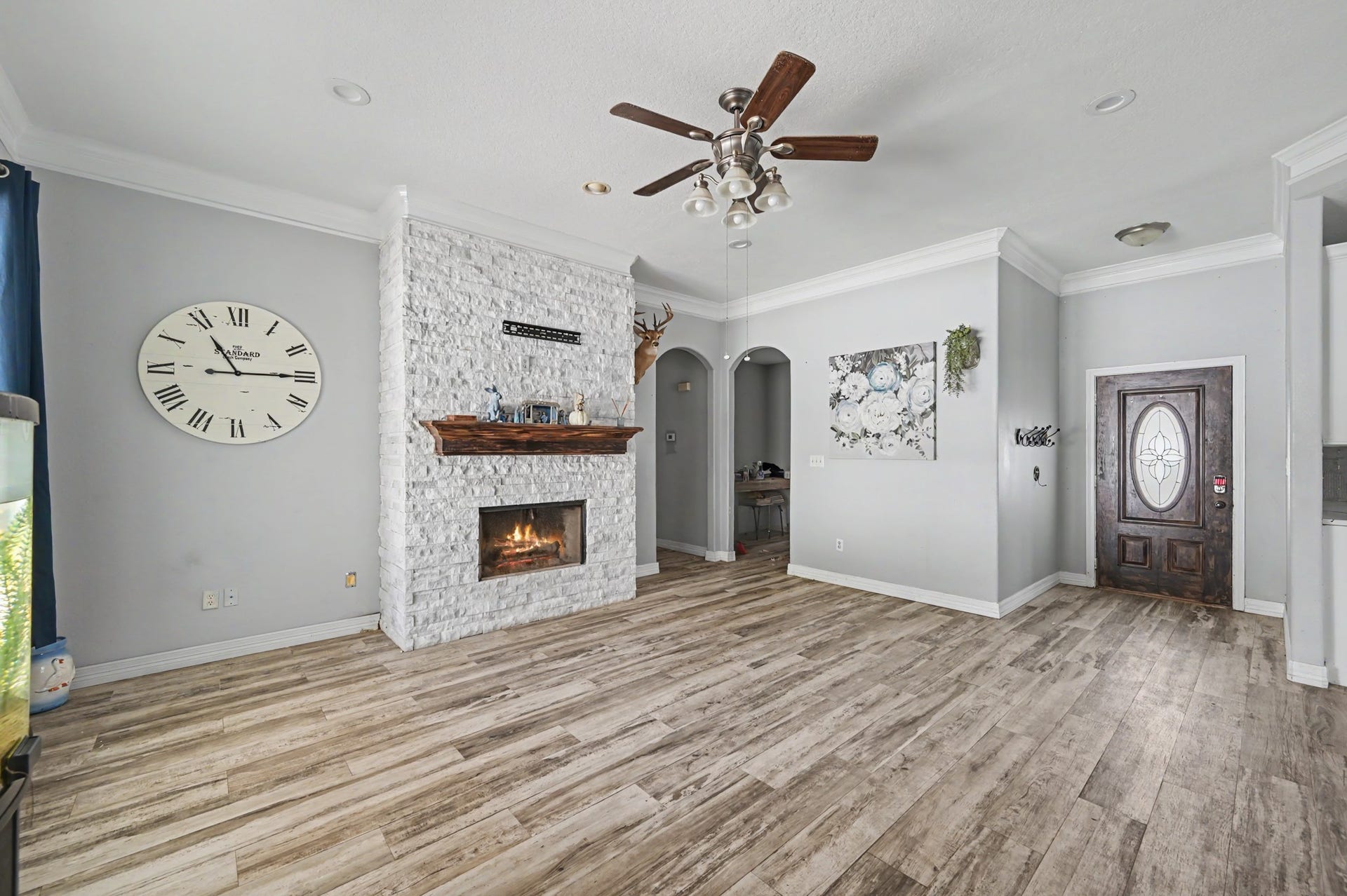 Another view of the open-concept living room showcasinbg the fireplace, arched openings and easy flow throughout the home.
