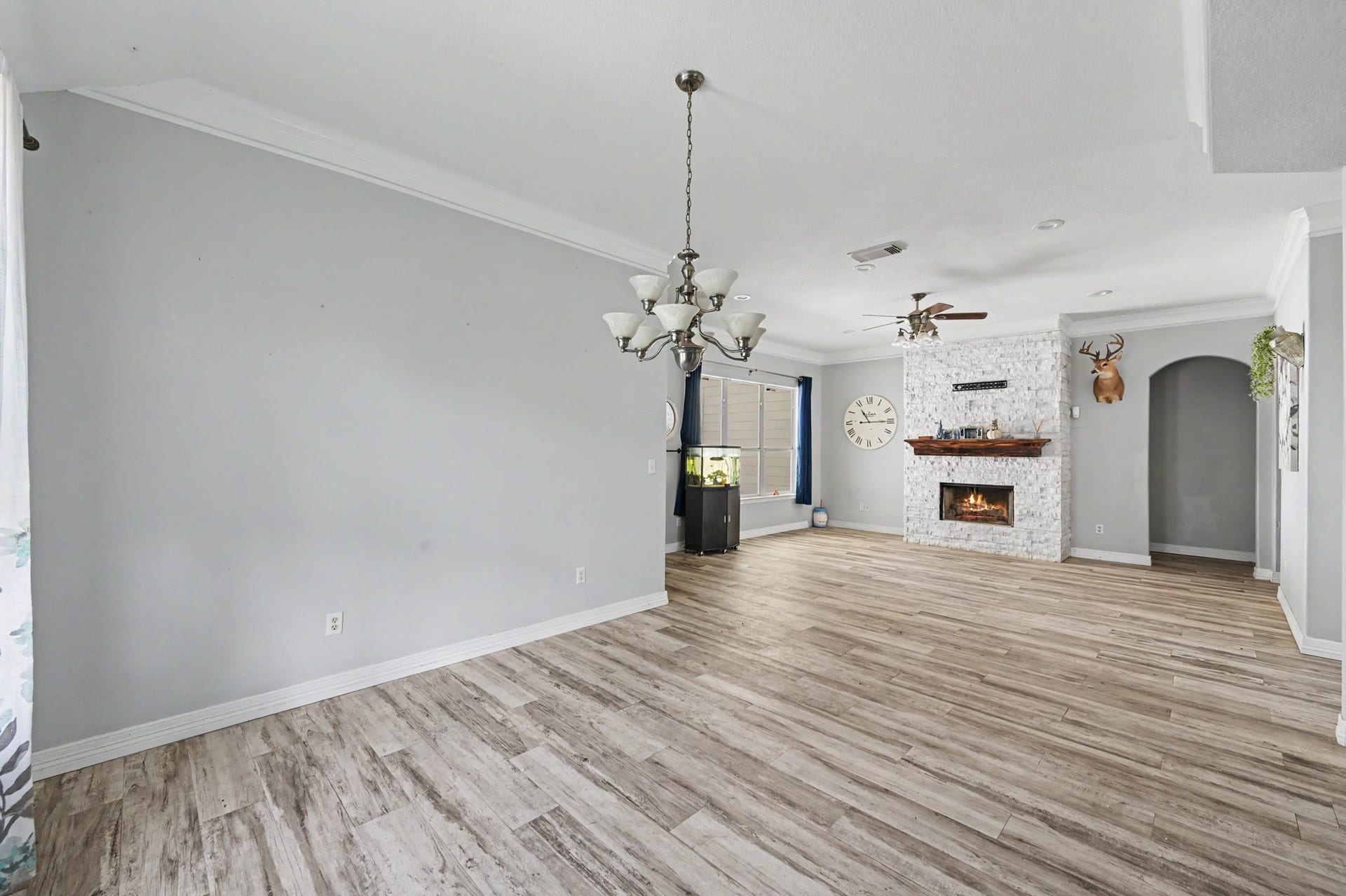 Spacious dining and living area showcasing the open layout, abundant natural light, and new tile flooring throughout.