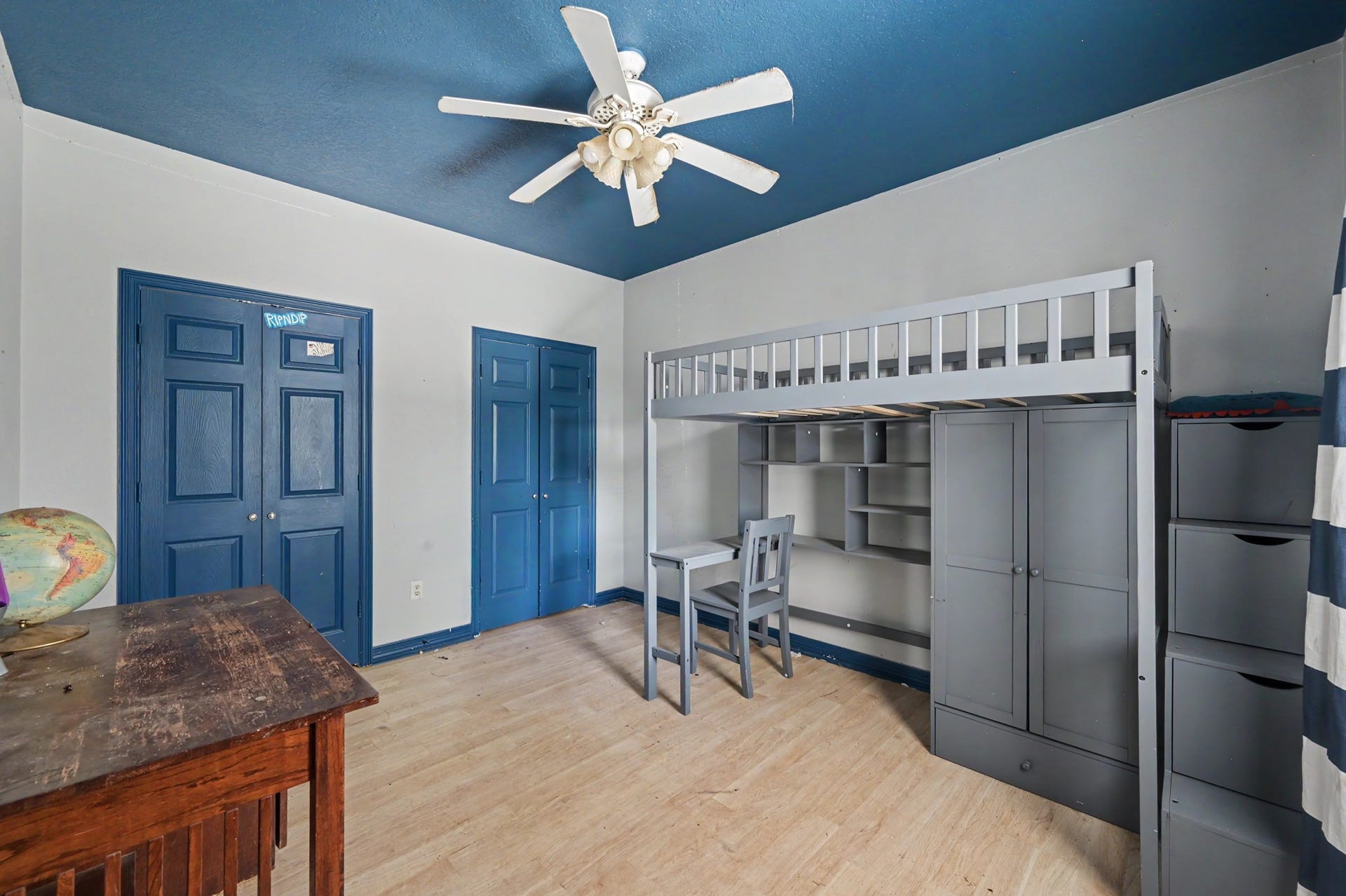 Additional bedroom or flex space with dramatic blue ceiling, coordinating doors, ceiling fan, and plenty of room for multiple uses.